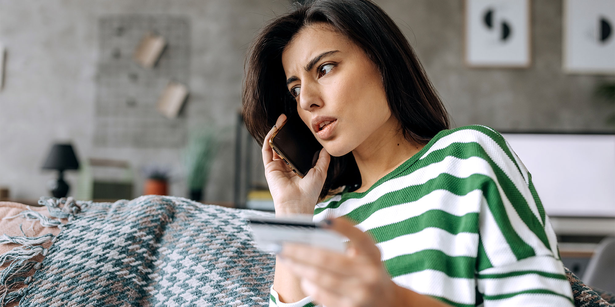 Someone on the phone while holding a credit card