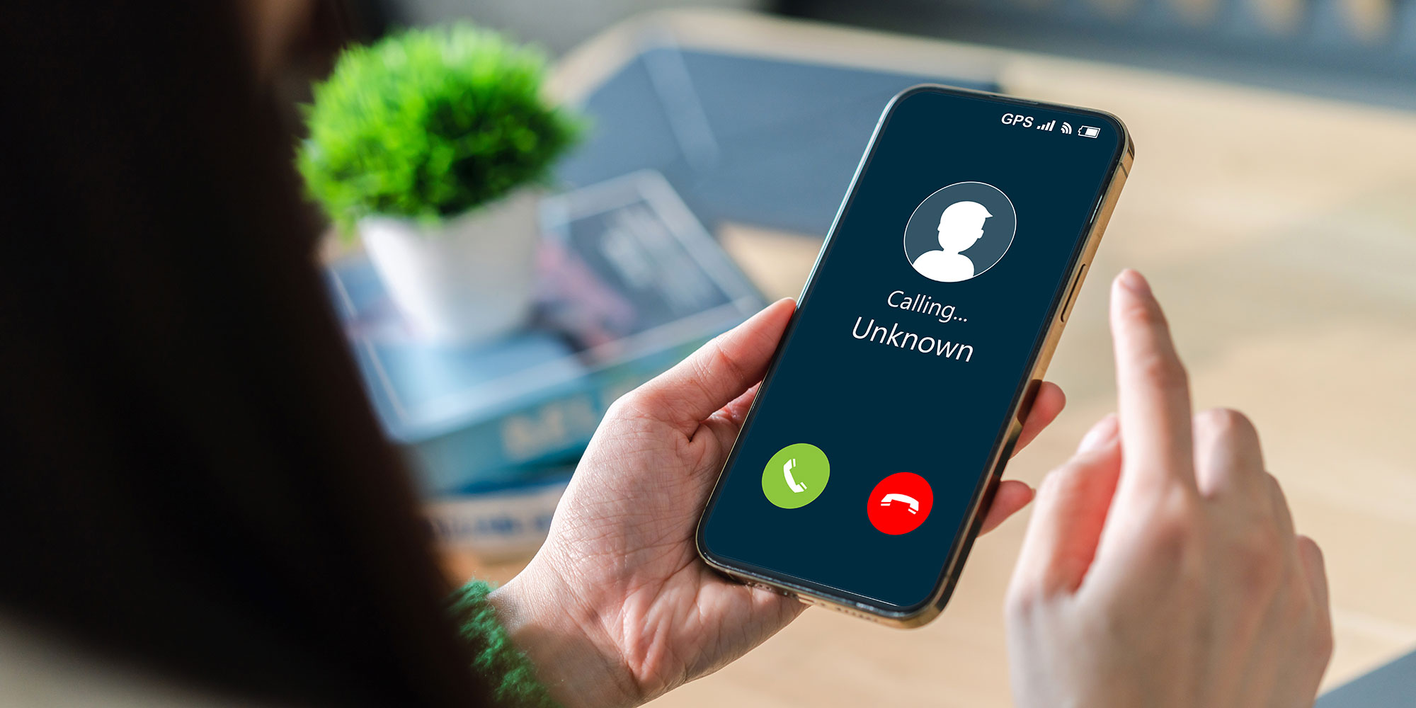 A person holding their phone while receiving a call from an unknown number