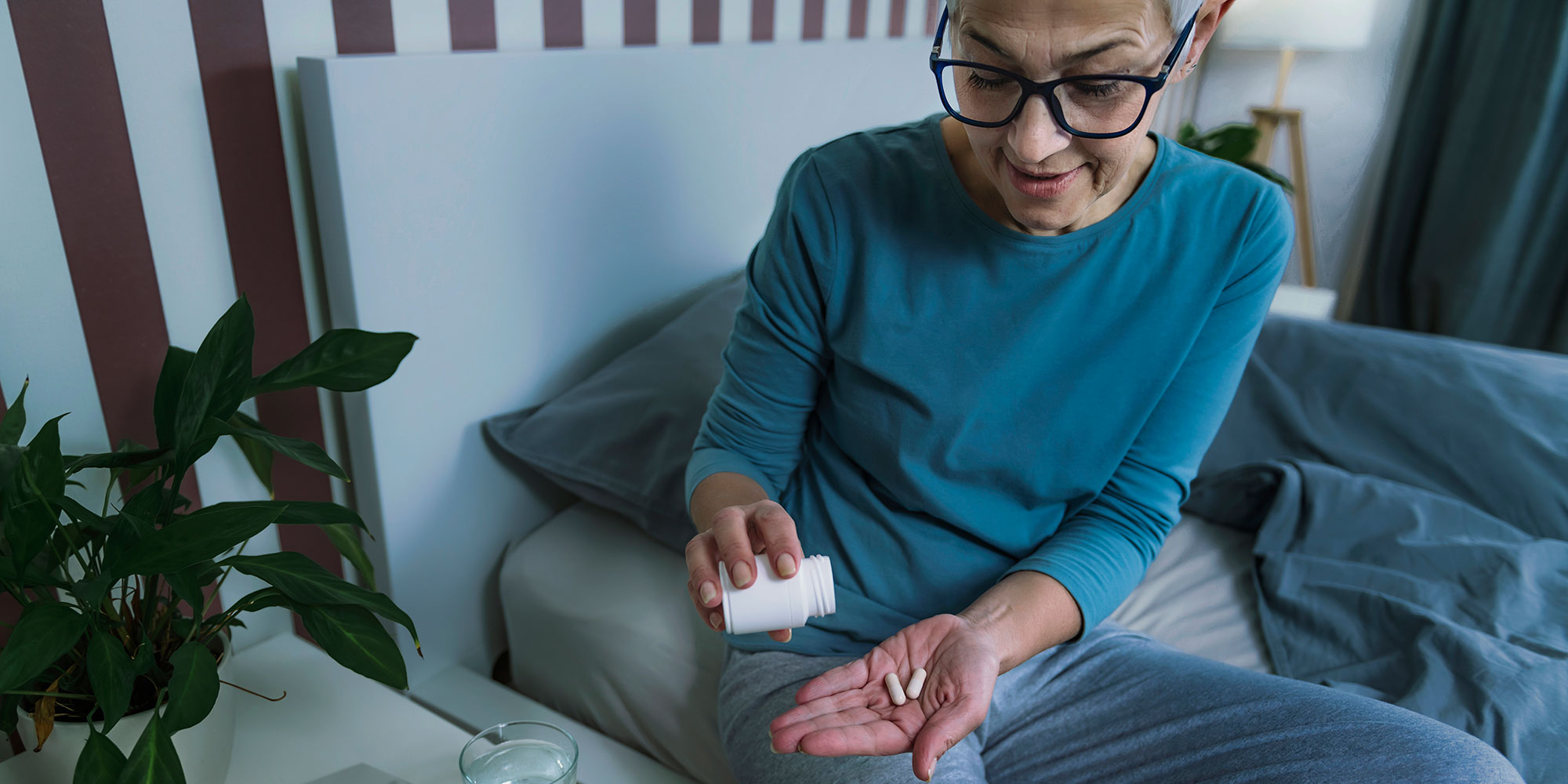 A woman preparing to take a supplement before bed