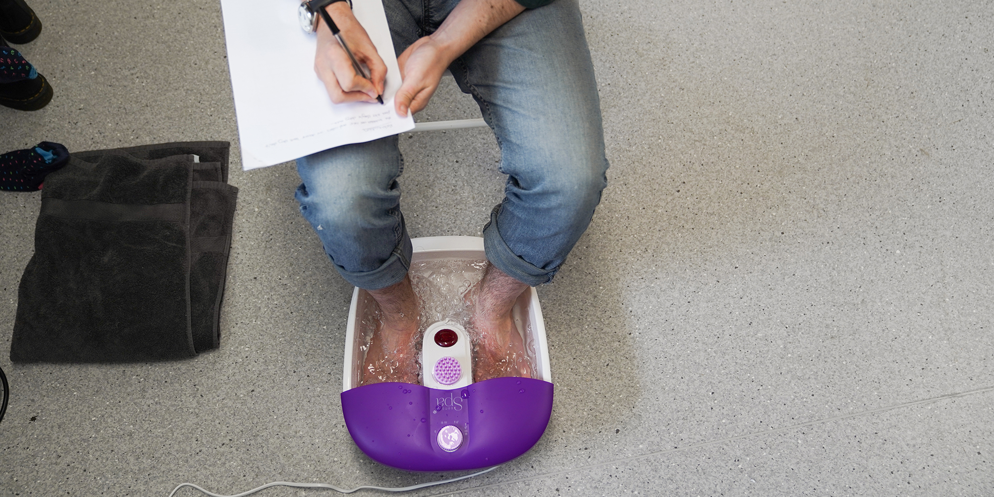 Which? expert foot spa relaxation test: man in jeans with bar feet in foot spa