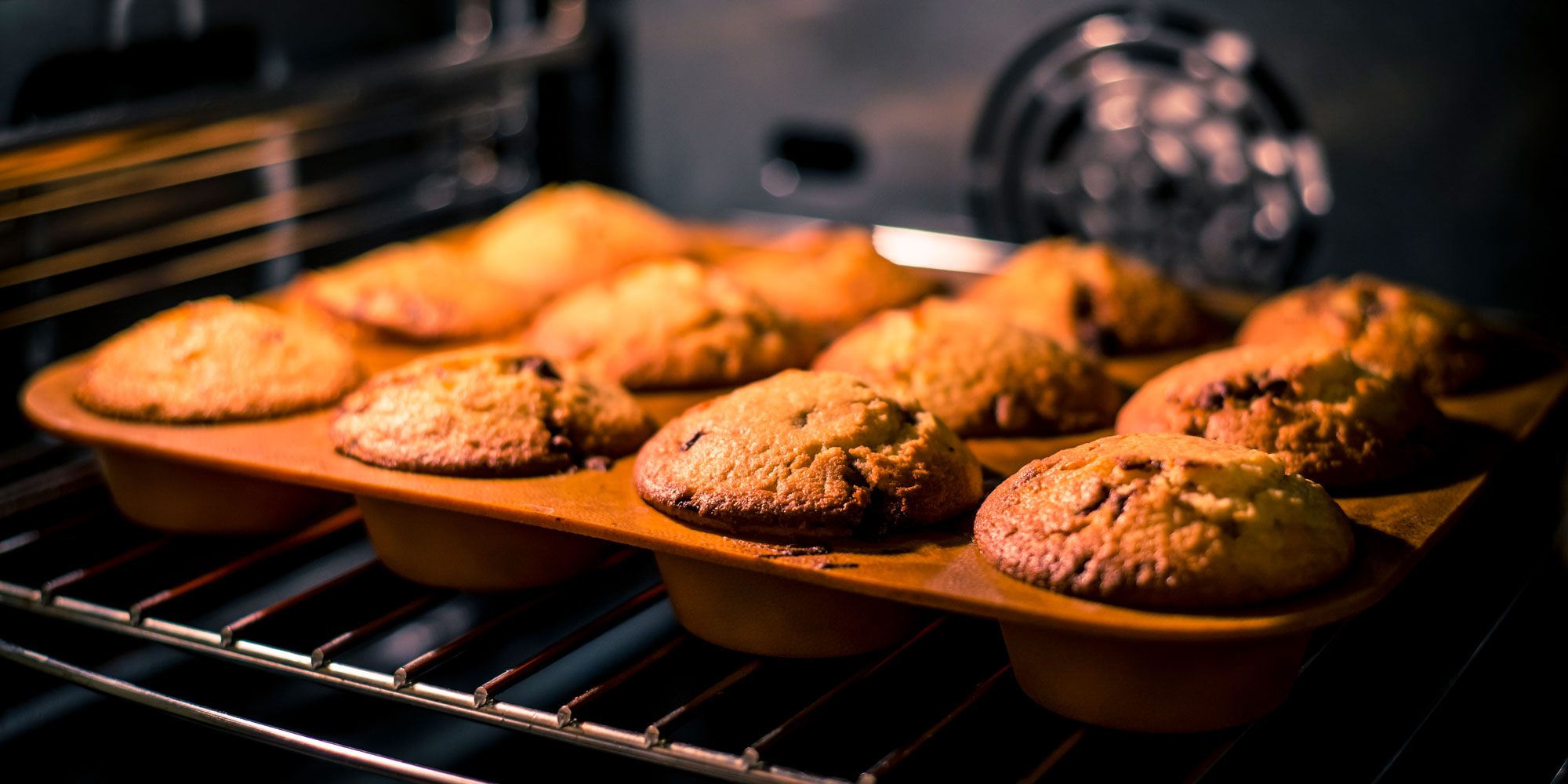 muffins rising and baking in an oven