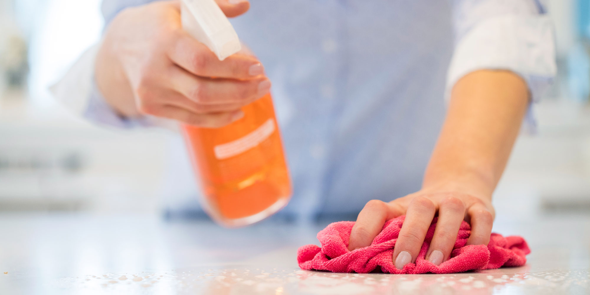 person wiping their kitchen surface