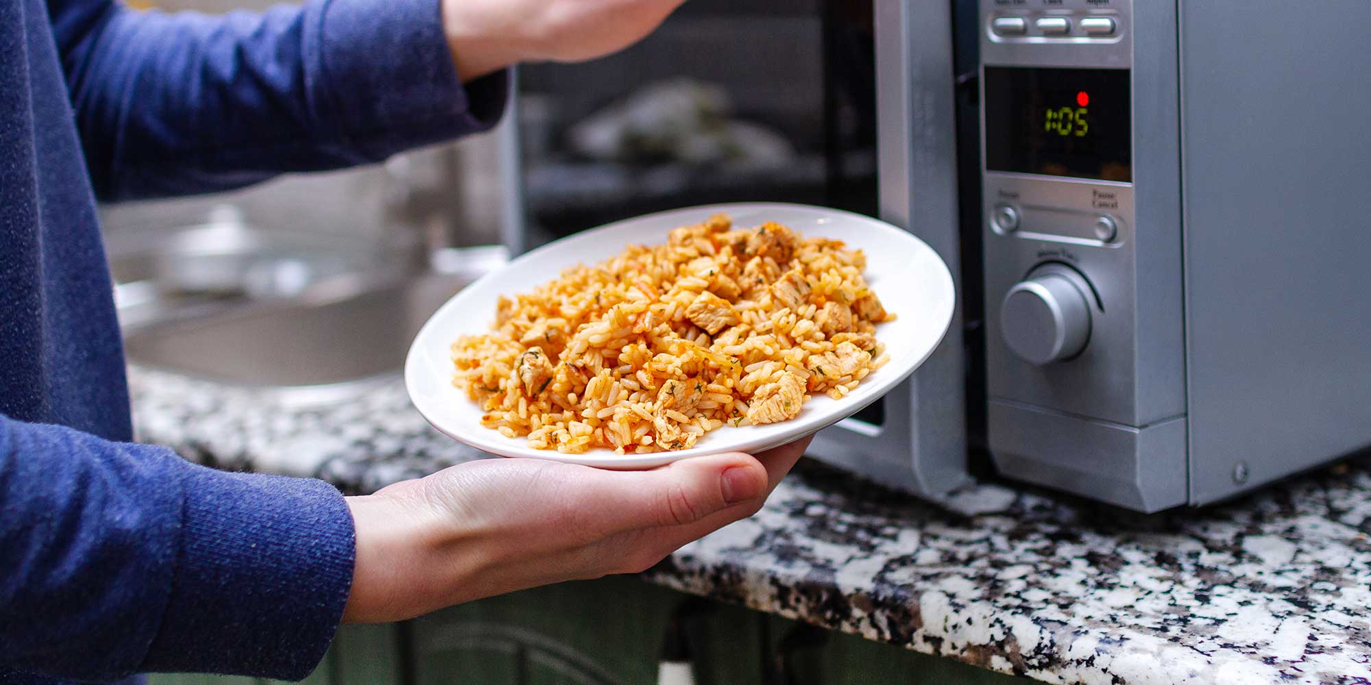 A person reheating rice in the microwave