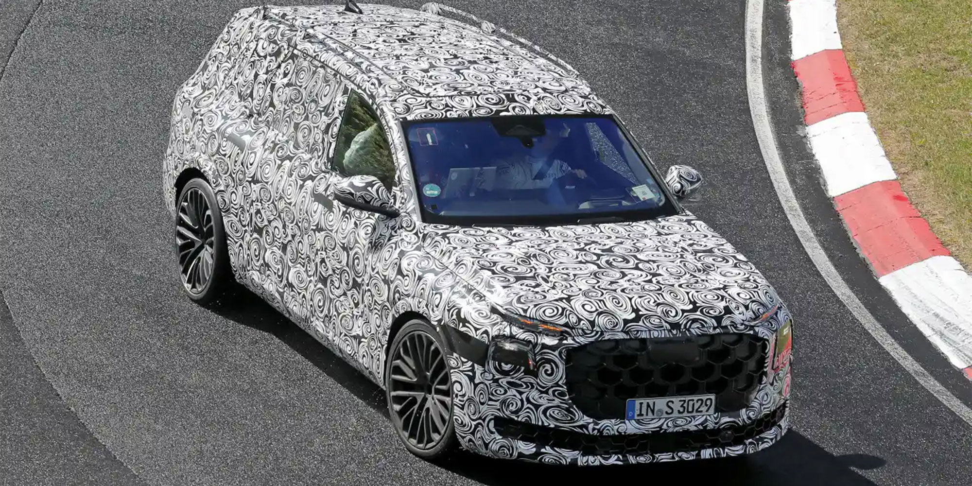 A camouflaged Audi Q9, being driven around the Nürburgring