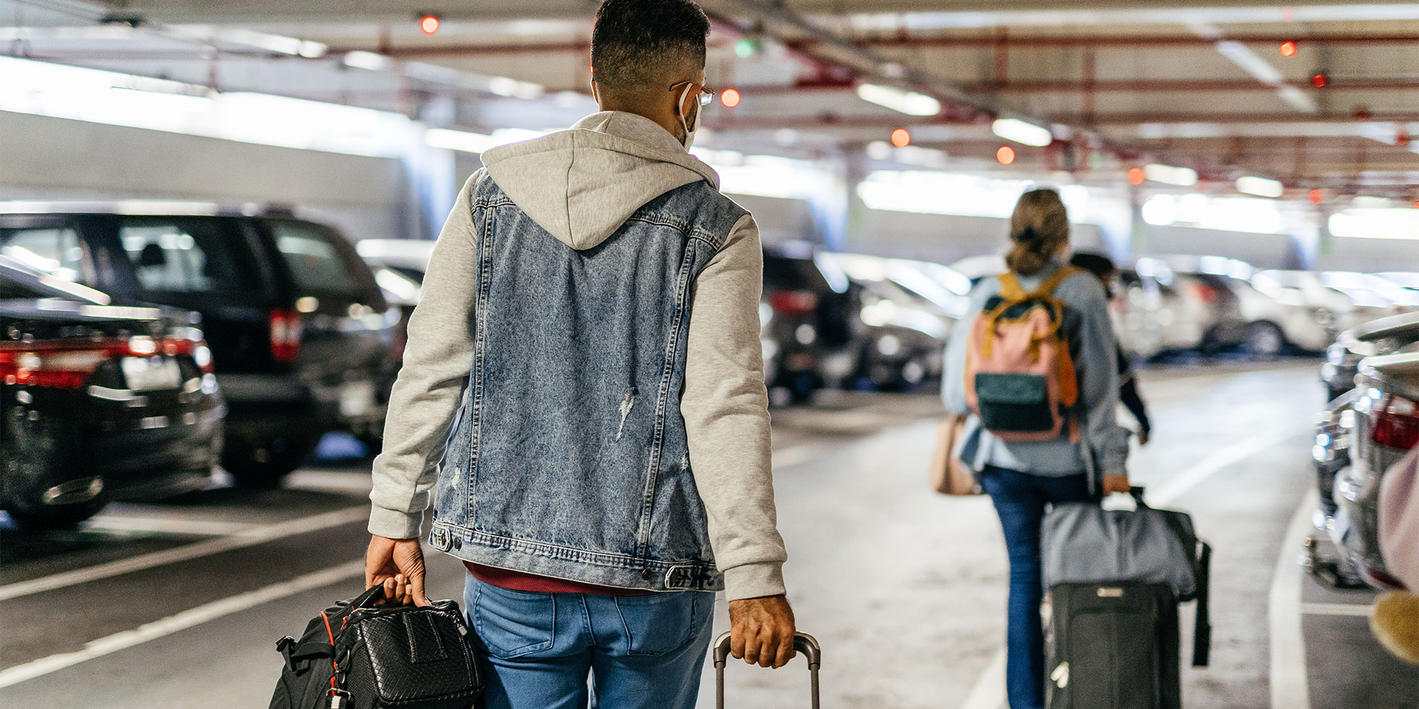 People walking through airport car park