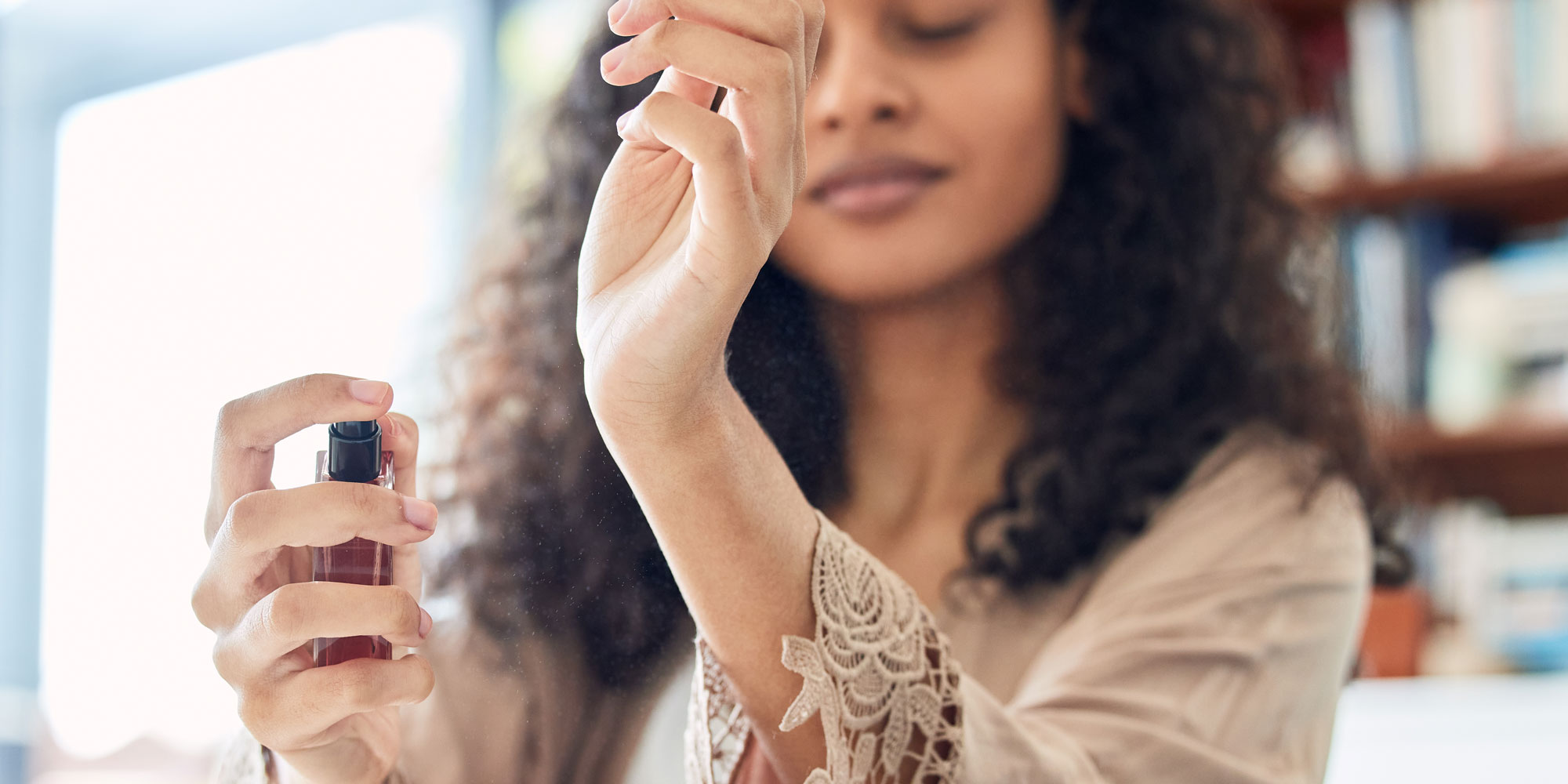Lady spraying perfume on wrist