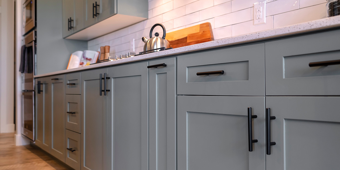 grey kitchen cabinets with black handles