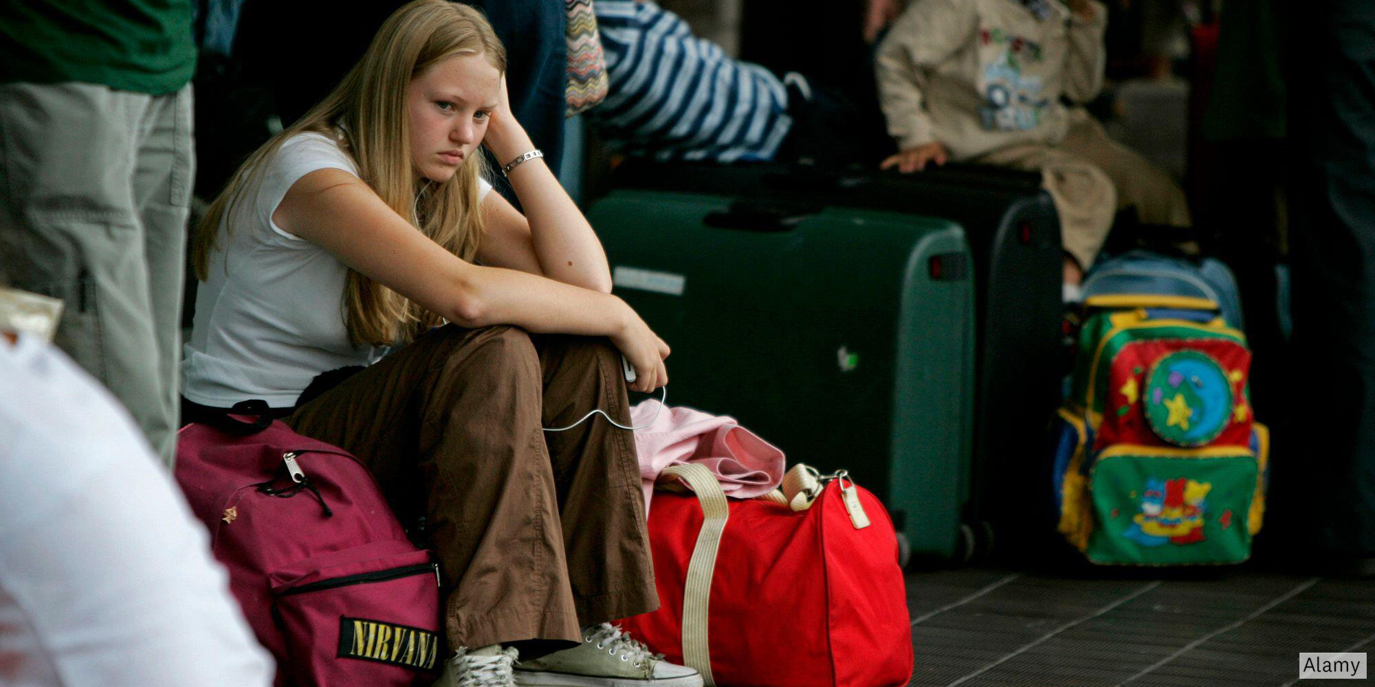 tired child surrounded by airport luggage