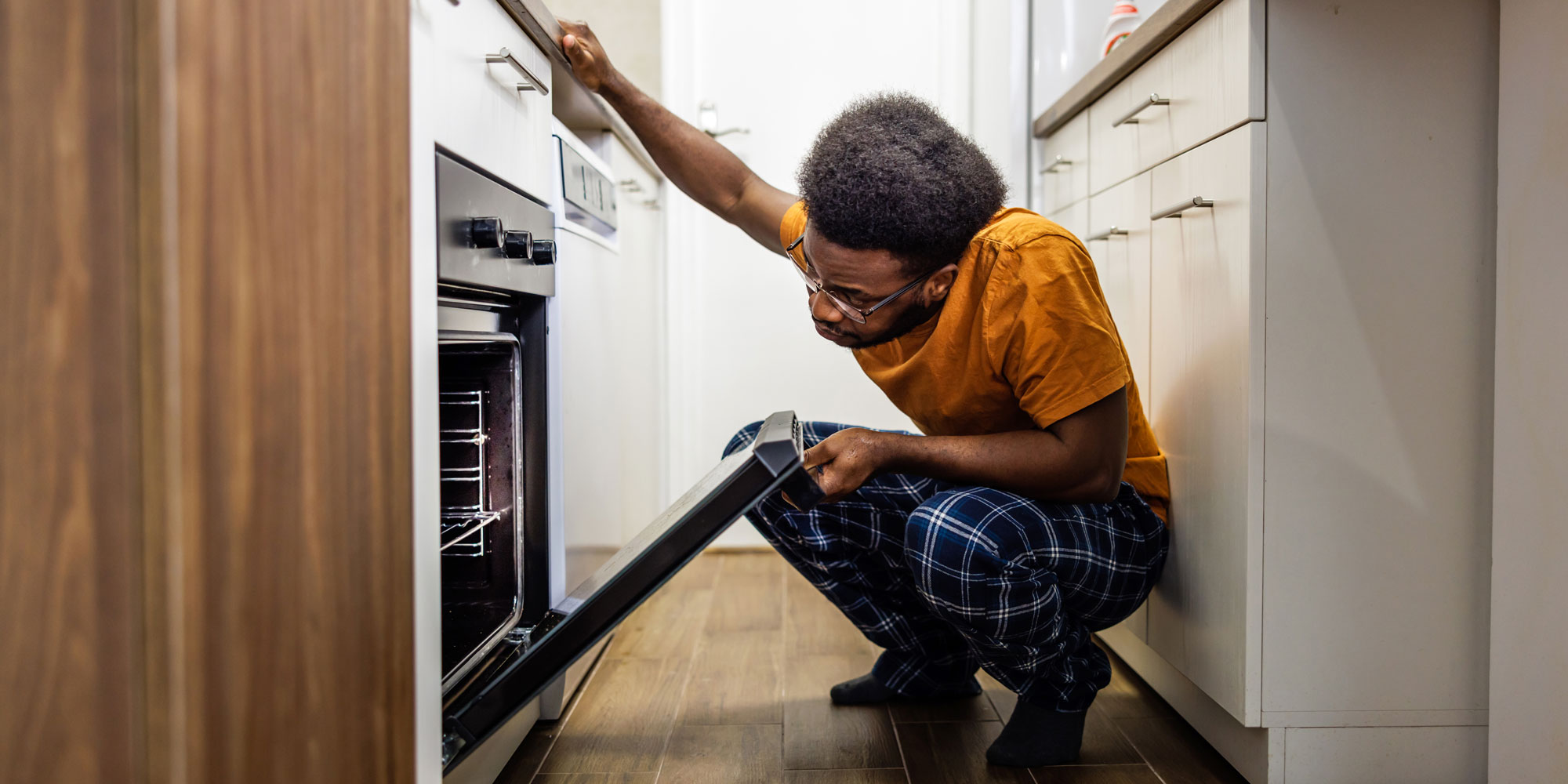 person opening an oven door to check on food inside