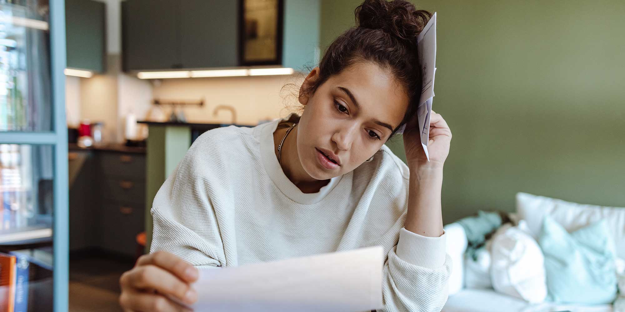A young woman staring at an energy bill
