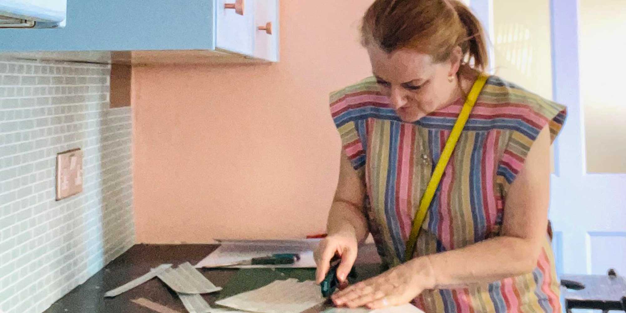 Martha Roberts, Which? senior researcher and writer, pictured cutting her stick-on kitchen tiles to the desired size