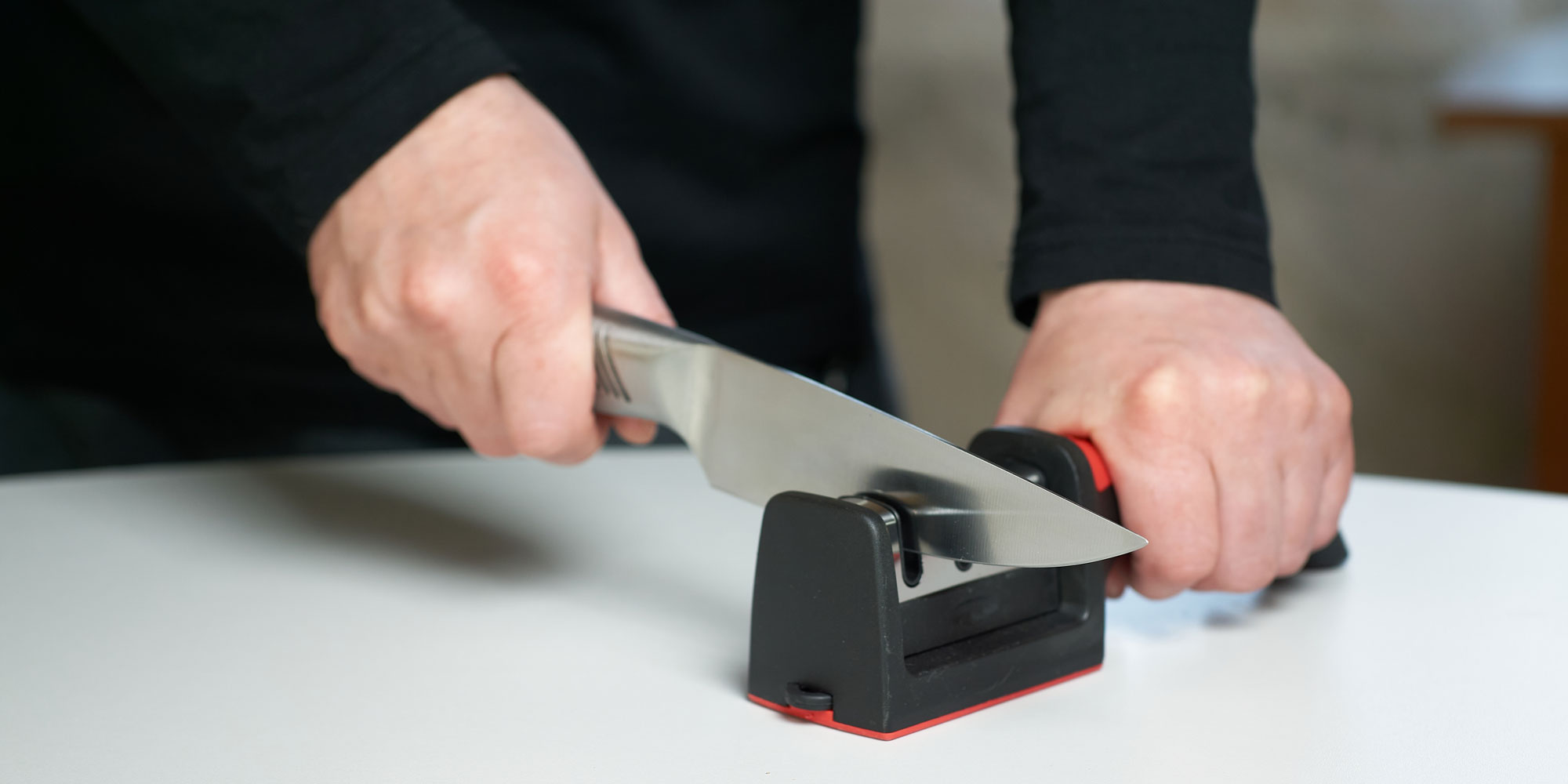 Image of person using manual knife sharpener