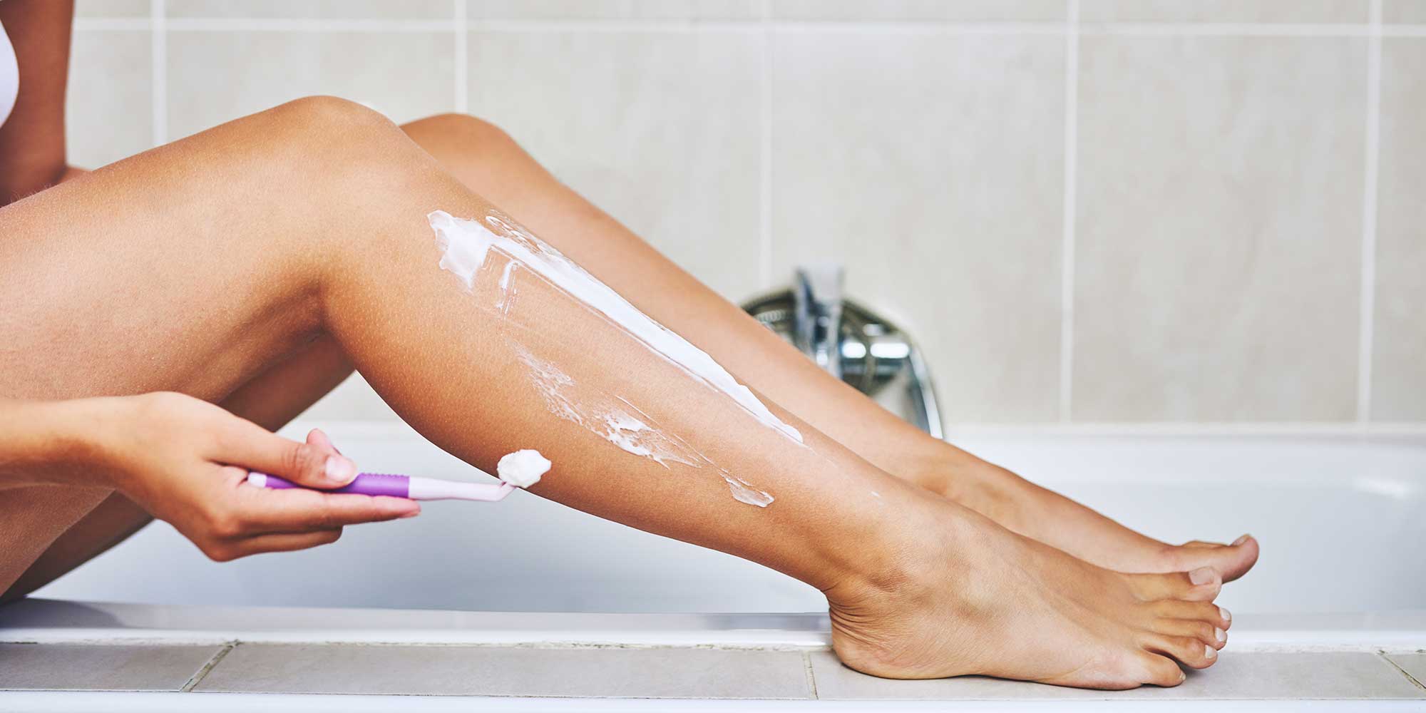 A woman shaving her legs