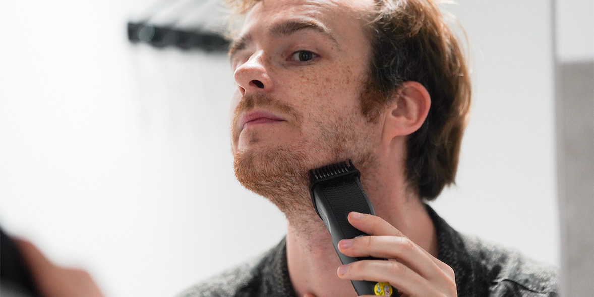 Man shaving jaw with beard trimmer