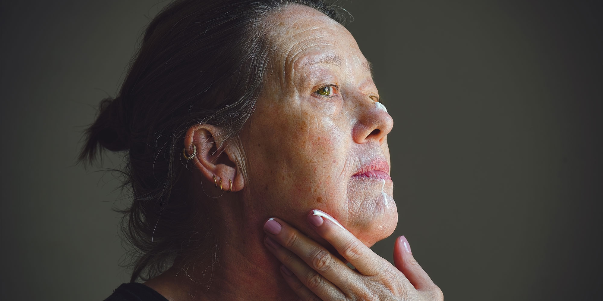 Woman applying moisturiser