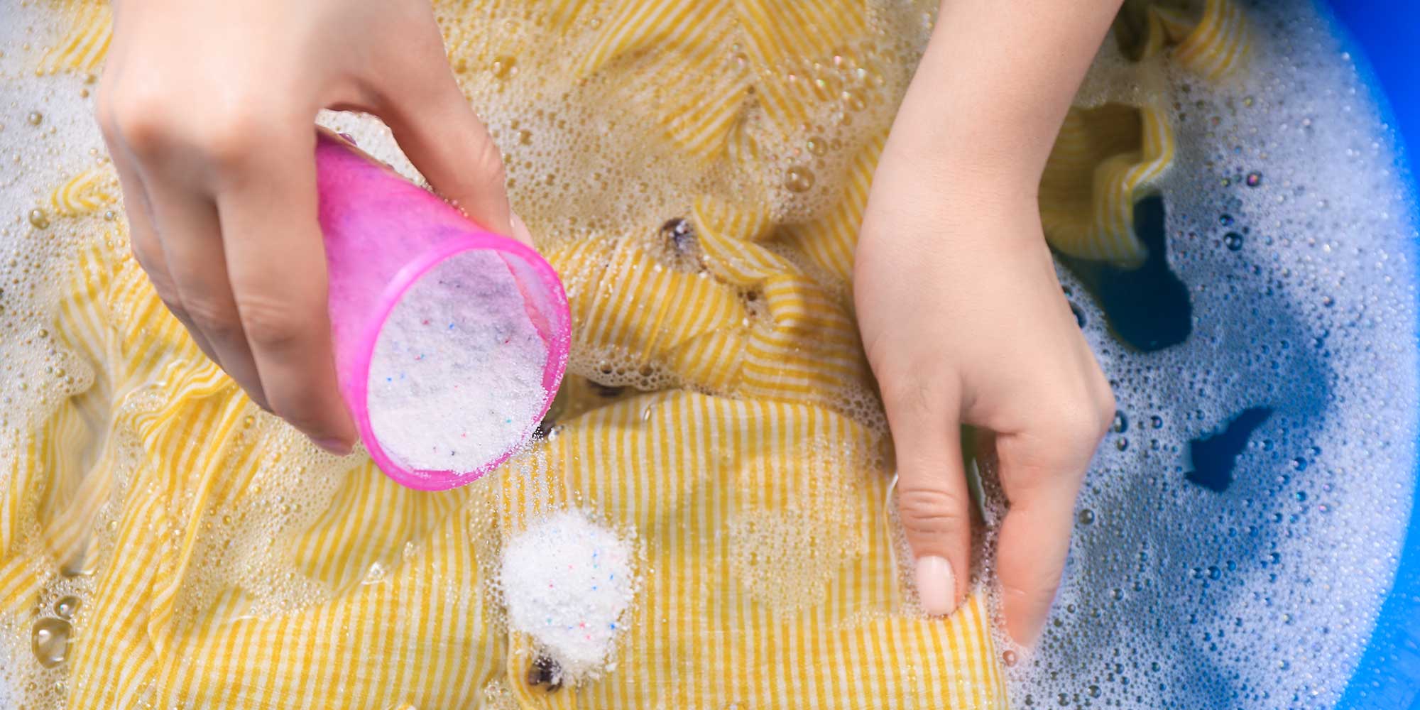 Pouring baking soda onto stained clothing