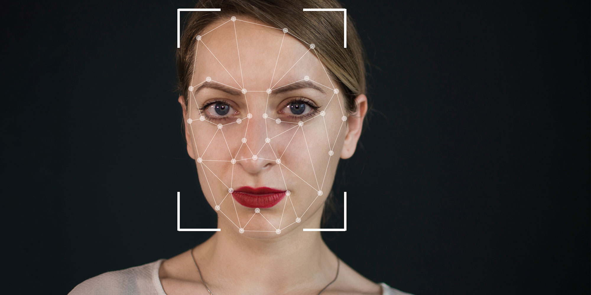 A woman stares at the camera with lines and dots on her face and a square over her face marking it as the focus point