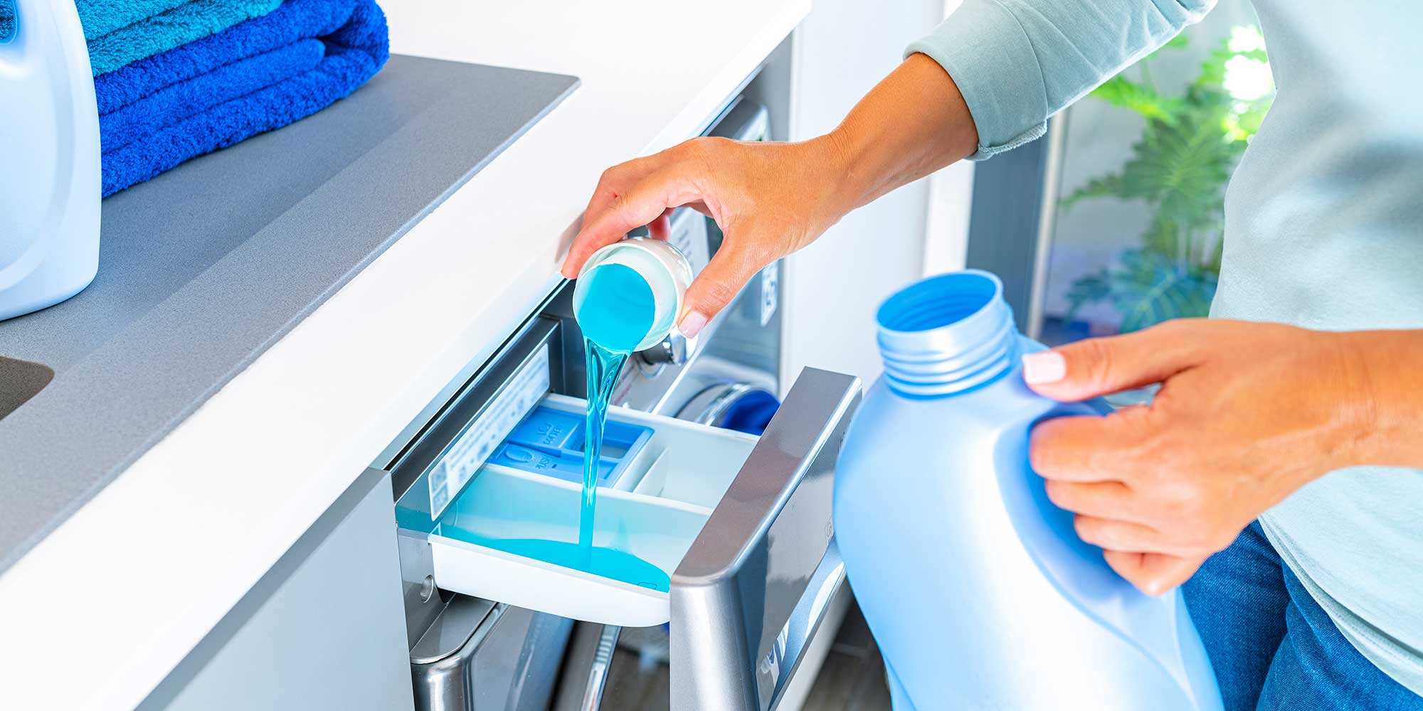 Fabric softener being poured into detergent drawer