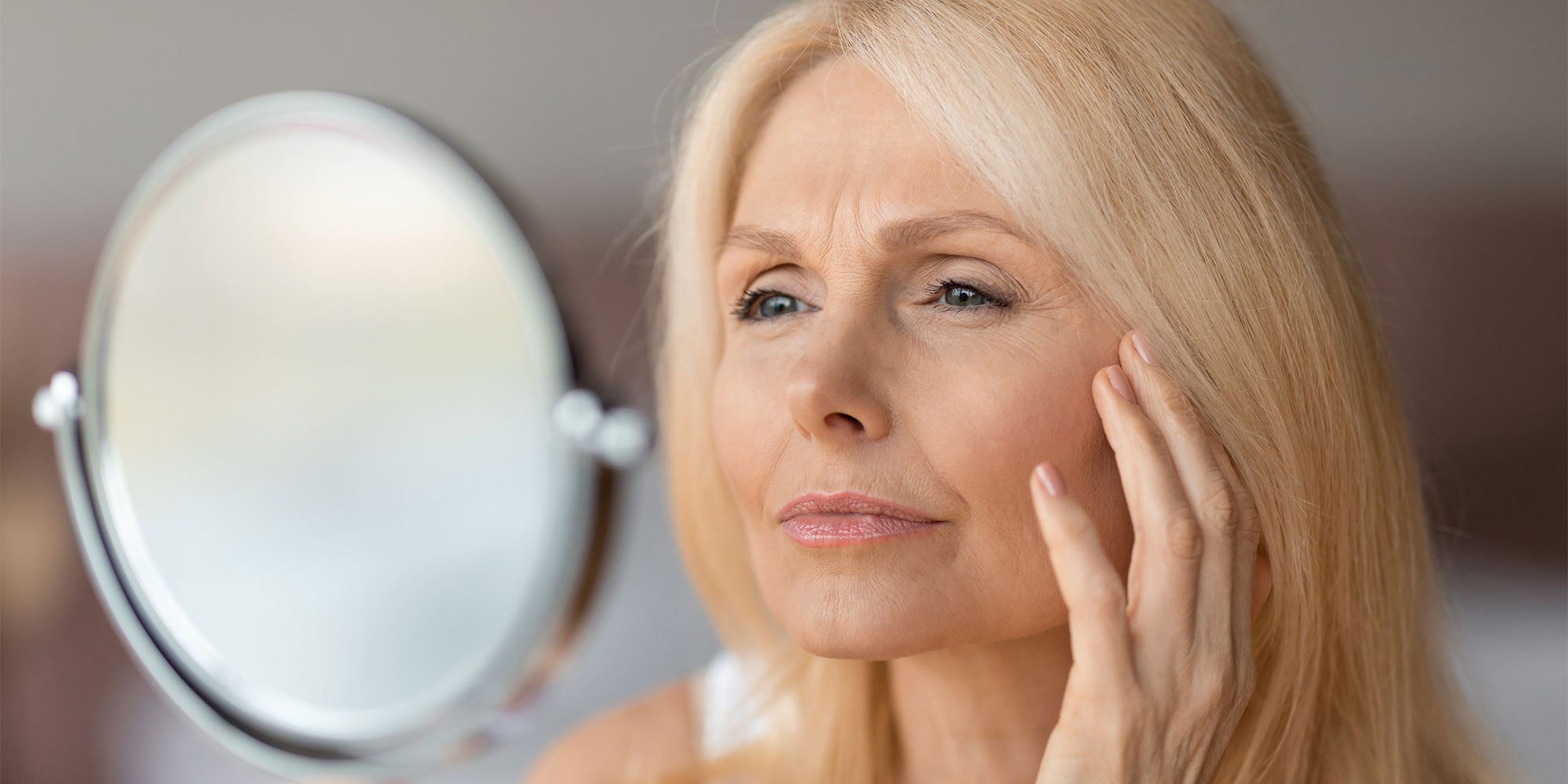 A person looking at their face in the mirror. 