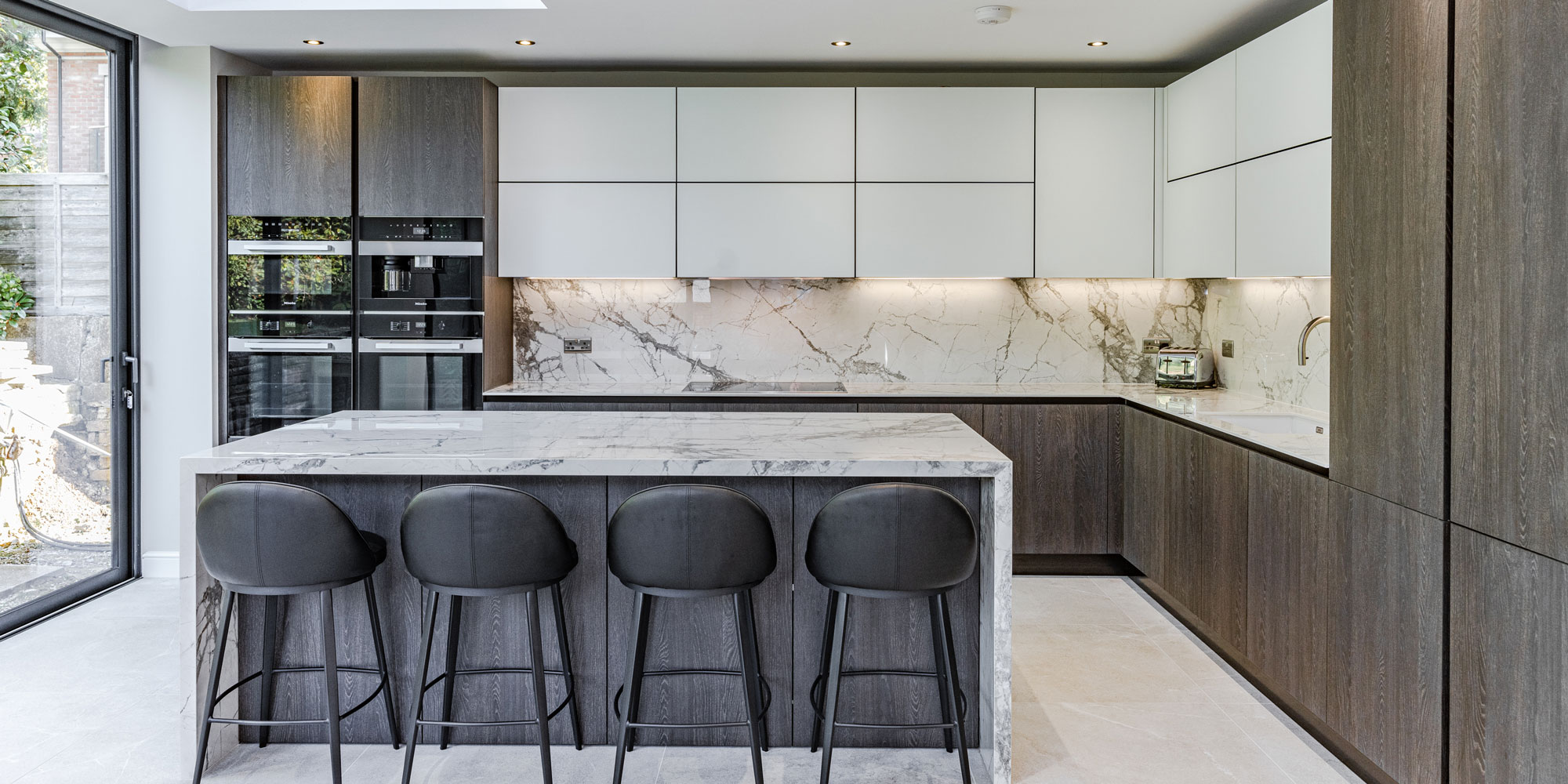 Grey wood kitchen with integrated fridge/freezer and ovens