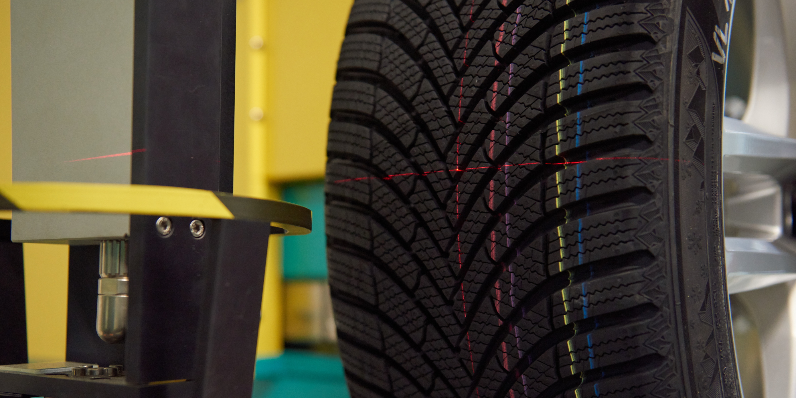 Car tyre tread being measured with a laser in a lab