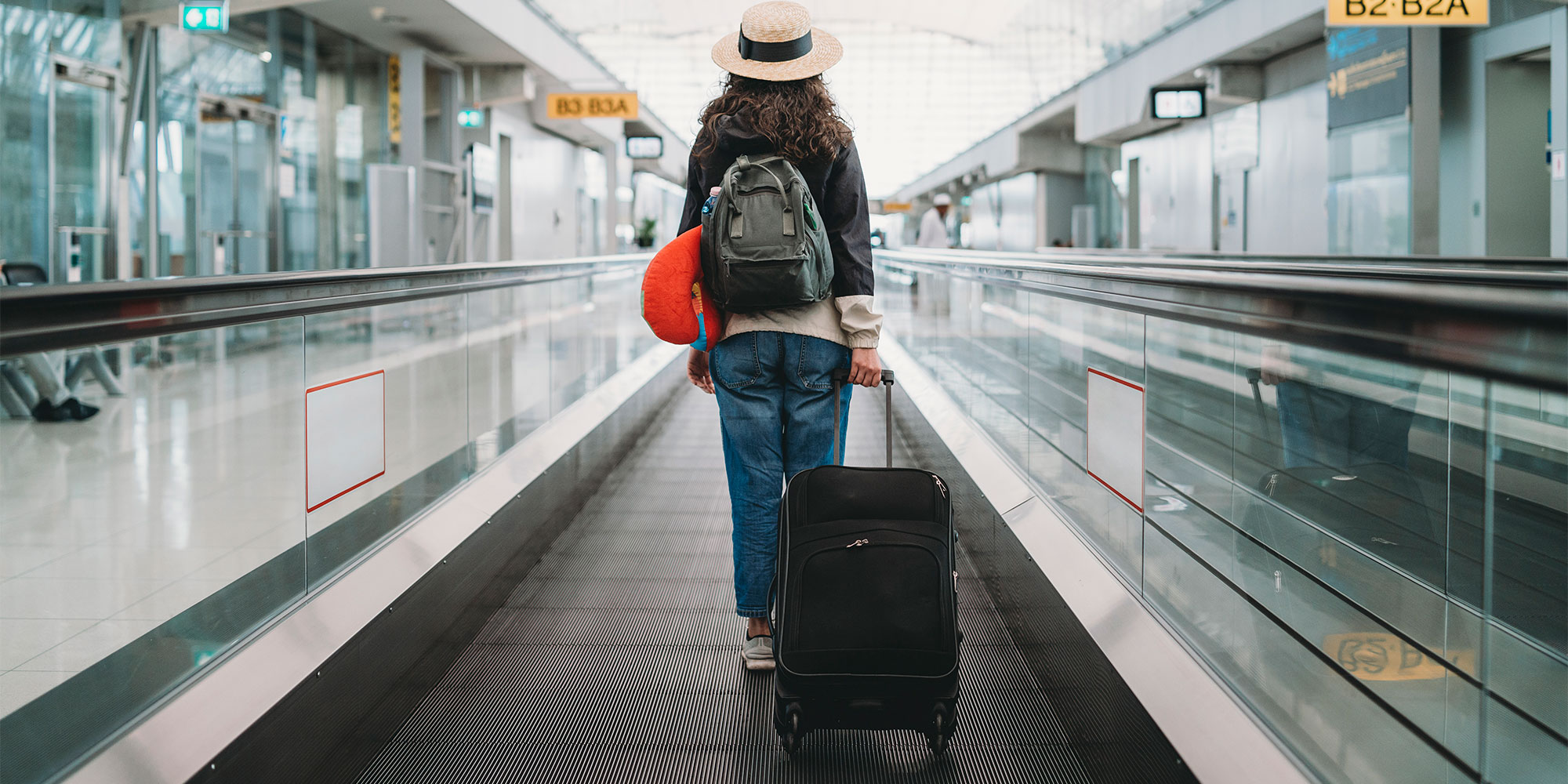 A person walking through an airport with hand luggage