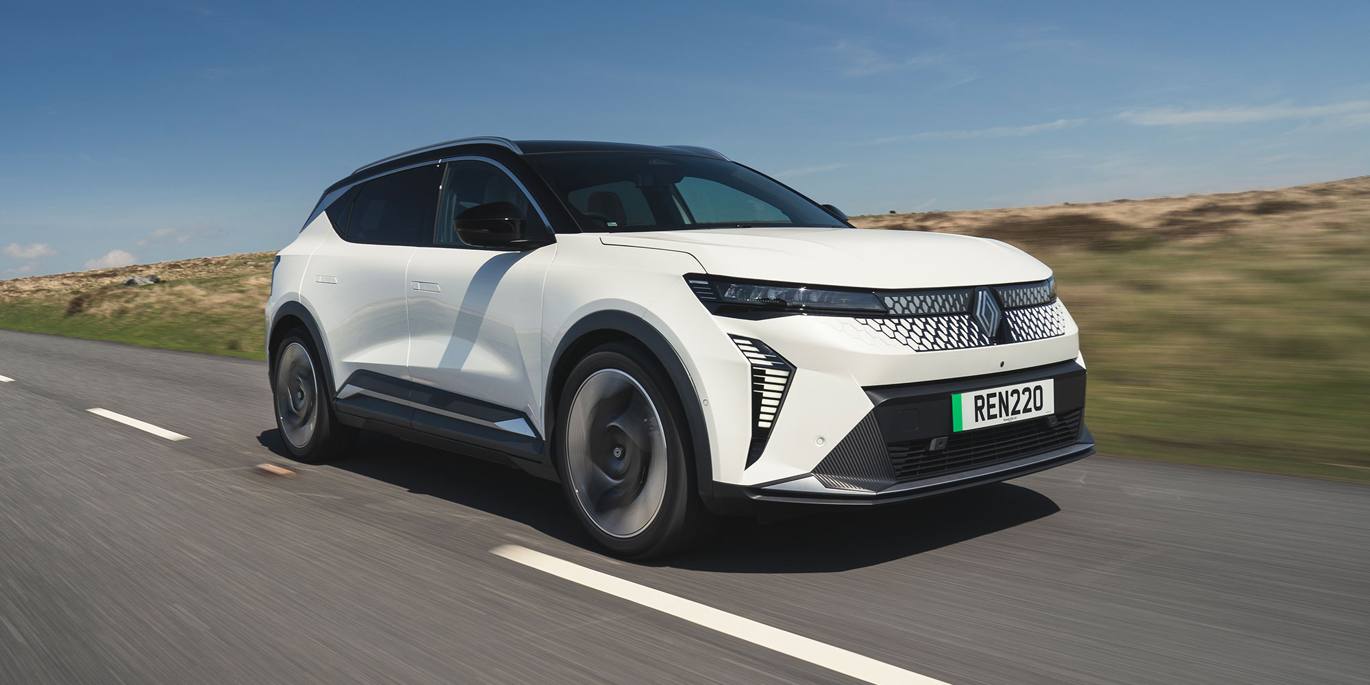 A white Renault Scenic E-Tech Electric, driving on a road