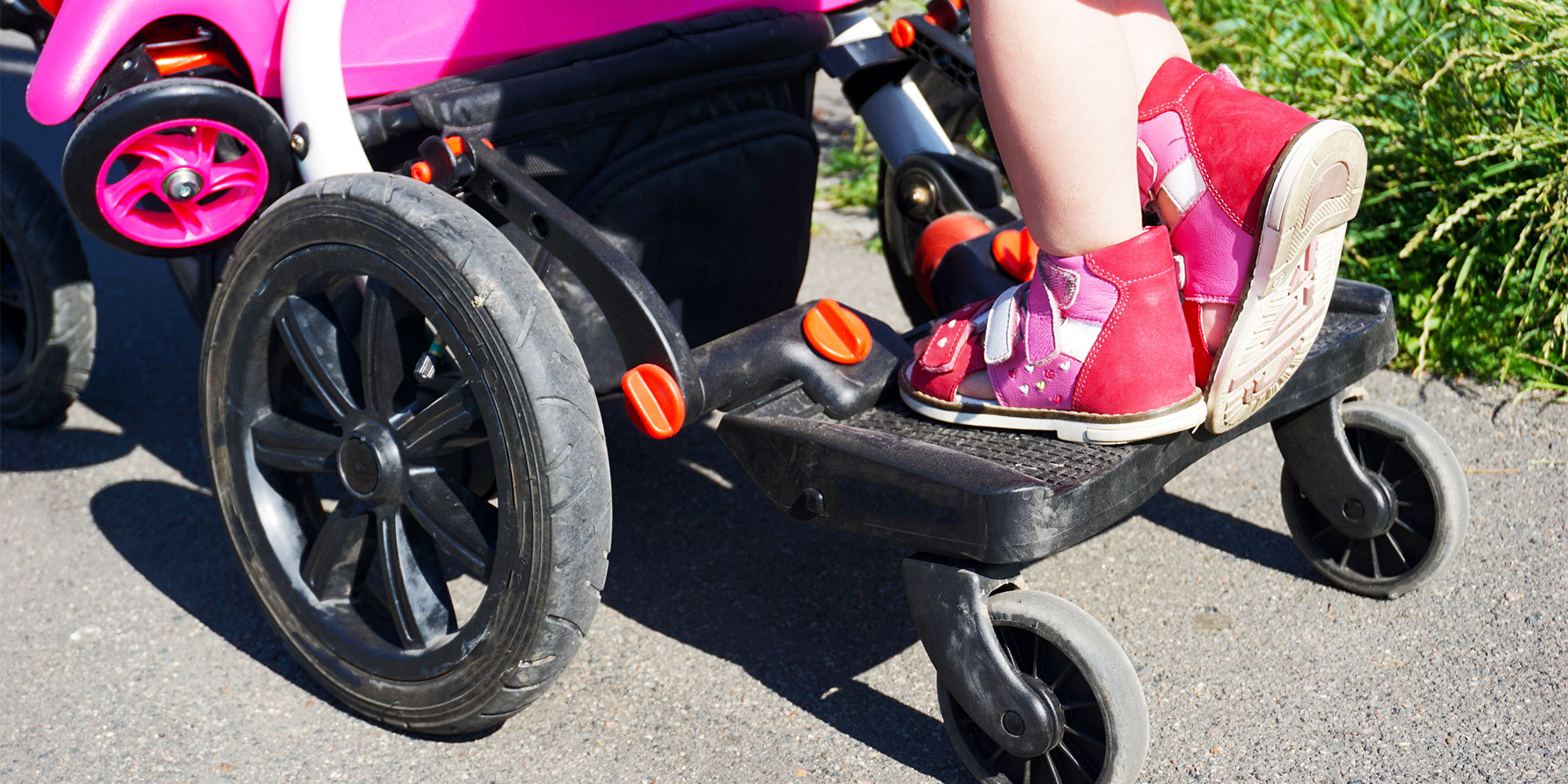 Buggy board on a pushchair with child standing on it