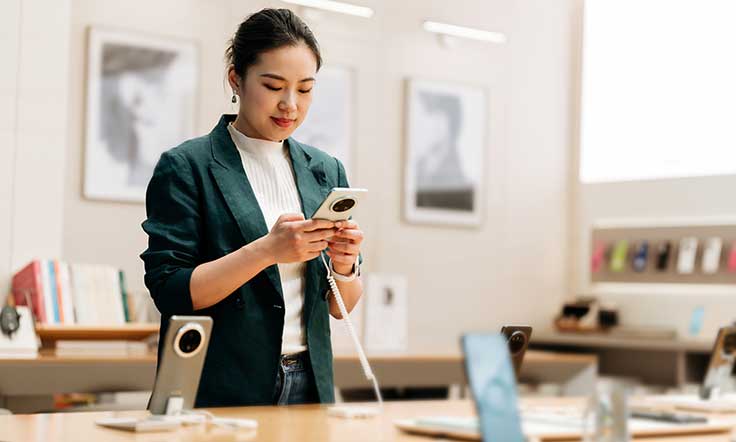 person in a technology shop looking at mobile phones