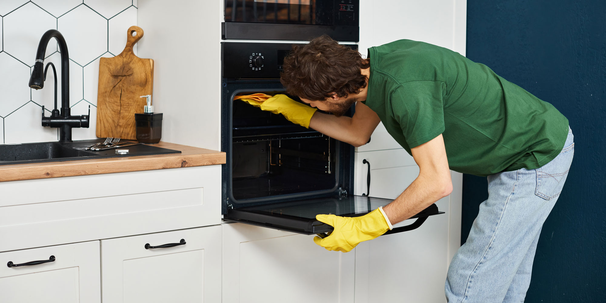 man cleaning the inside of an oven