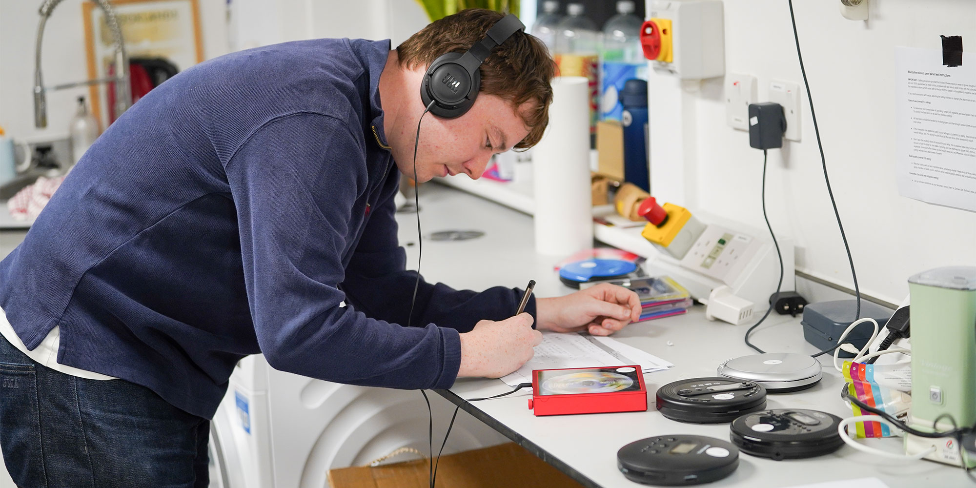 A Which? expert evaluating portable CD players in our testing room.