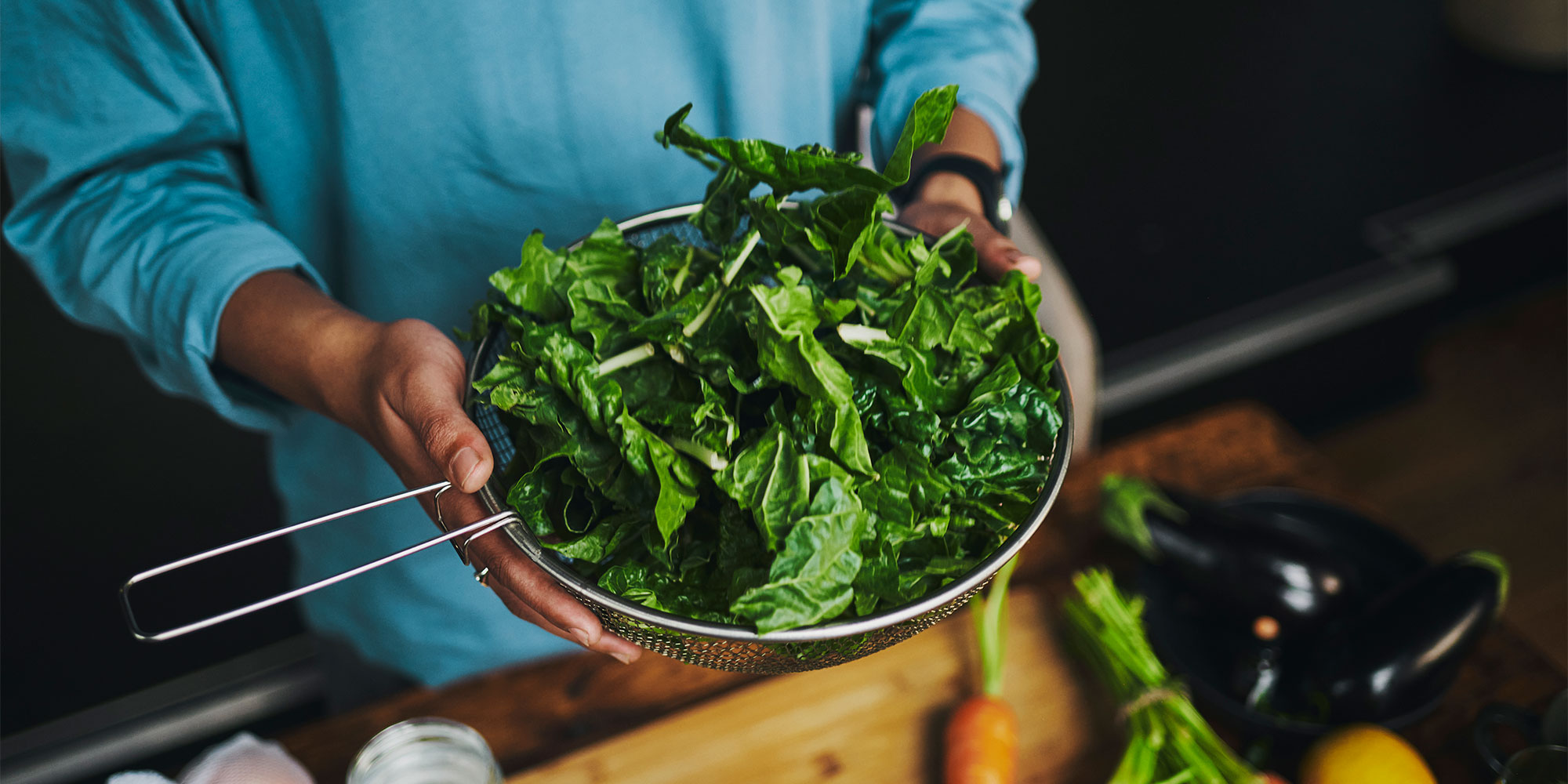 Woman holding leafy greens great for healthy bowels 