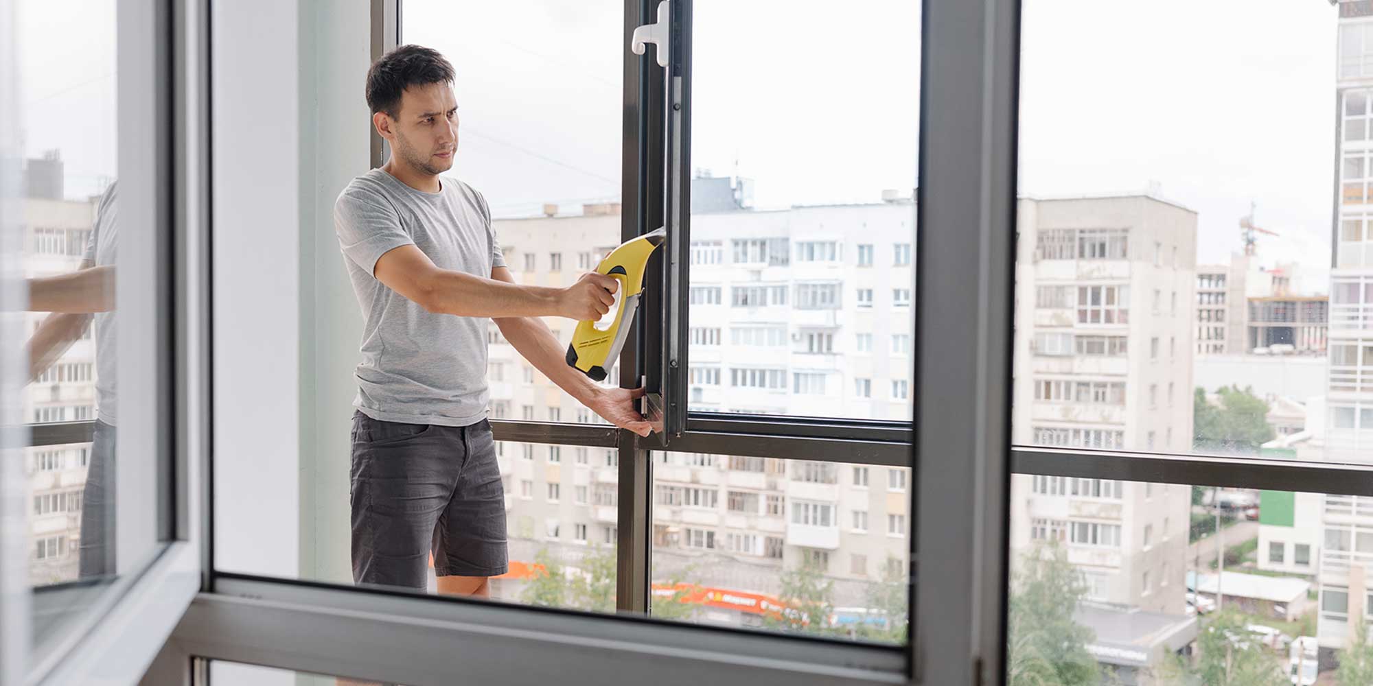 person using a window vac to clean windows