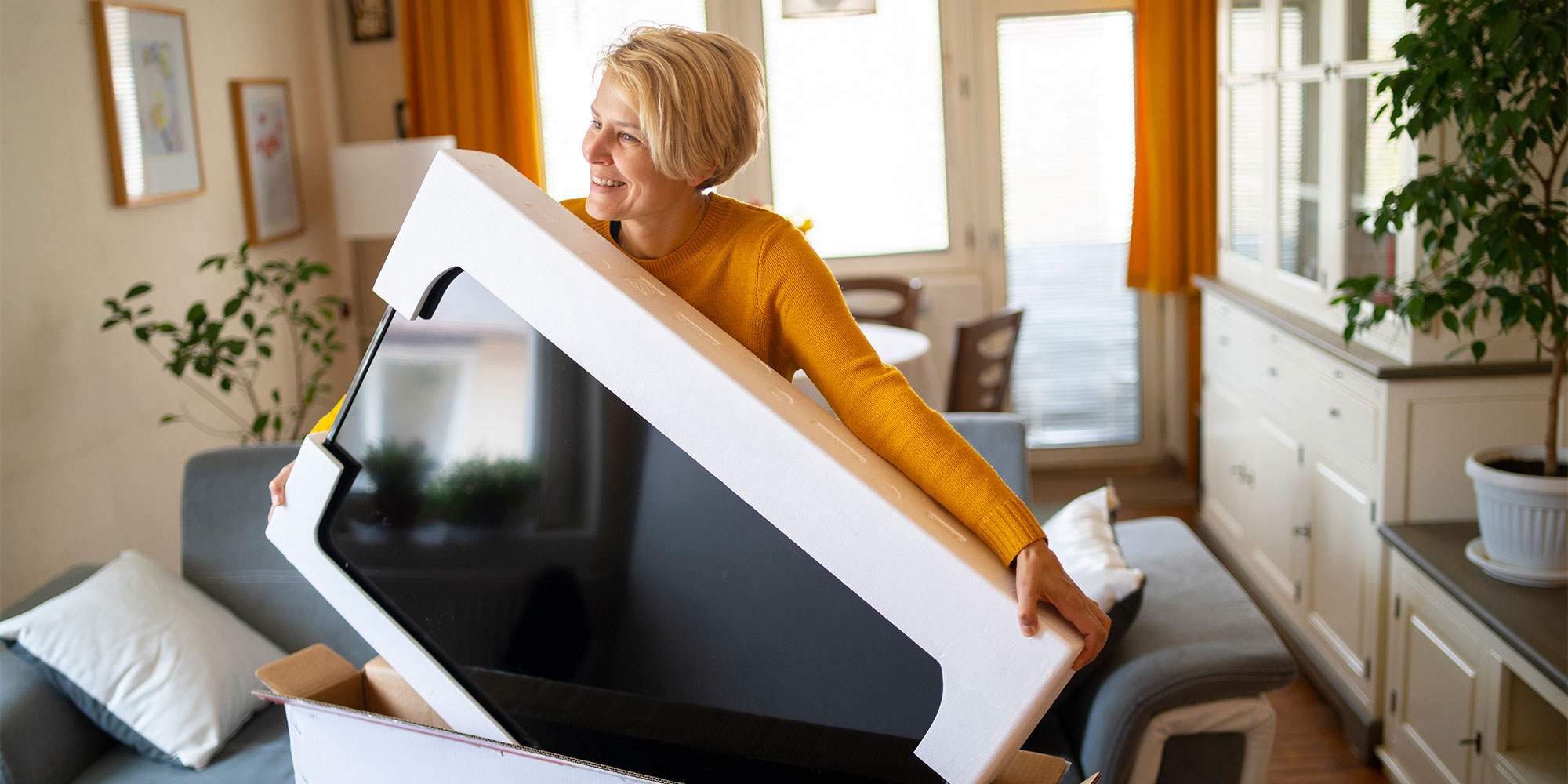 Person setting up their new TV at home