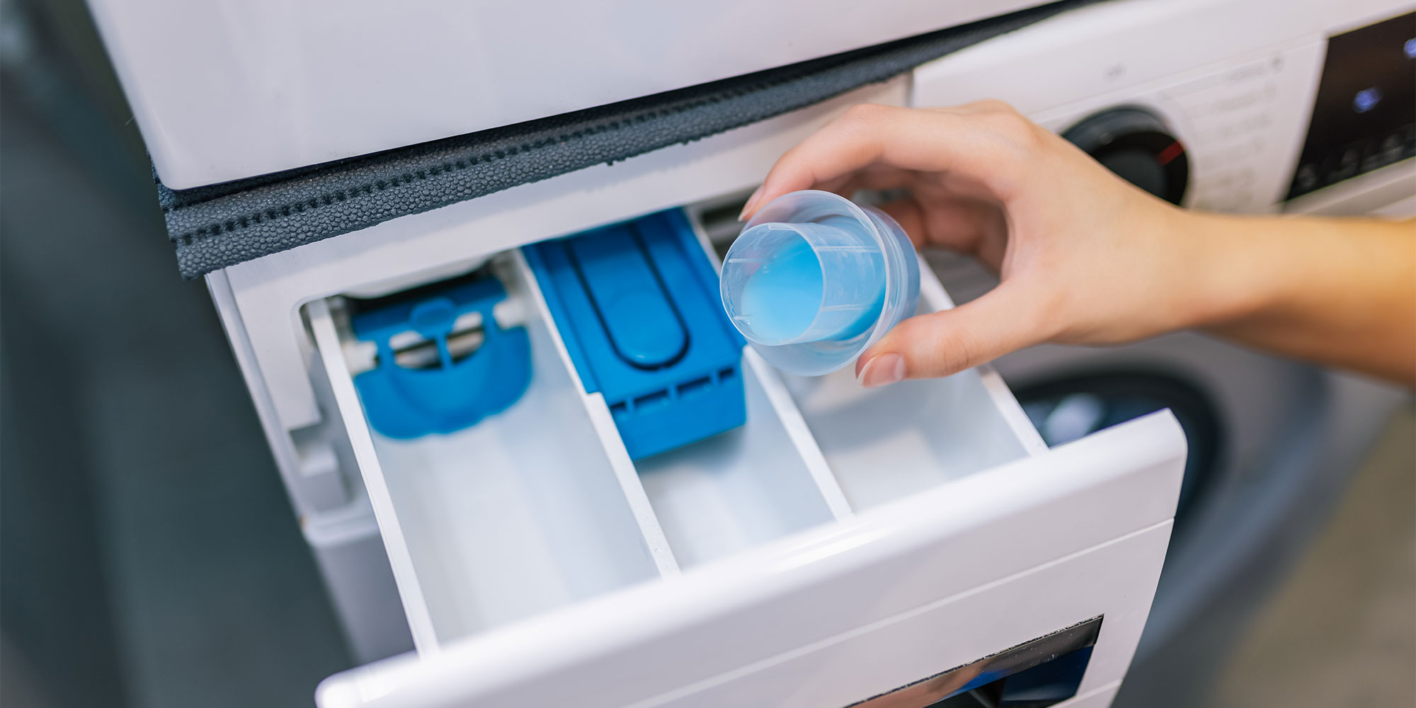 Pouring fabric softener into drawer