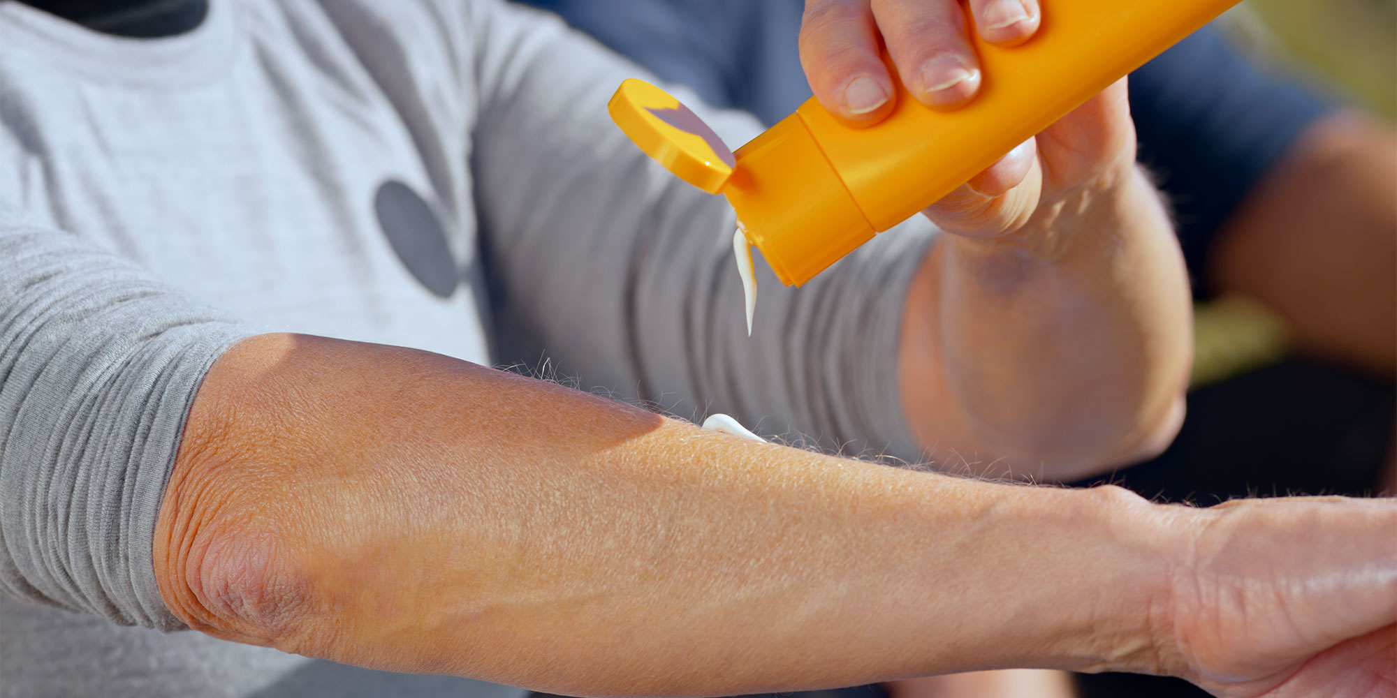 man applying sunscreen to arm