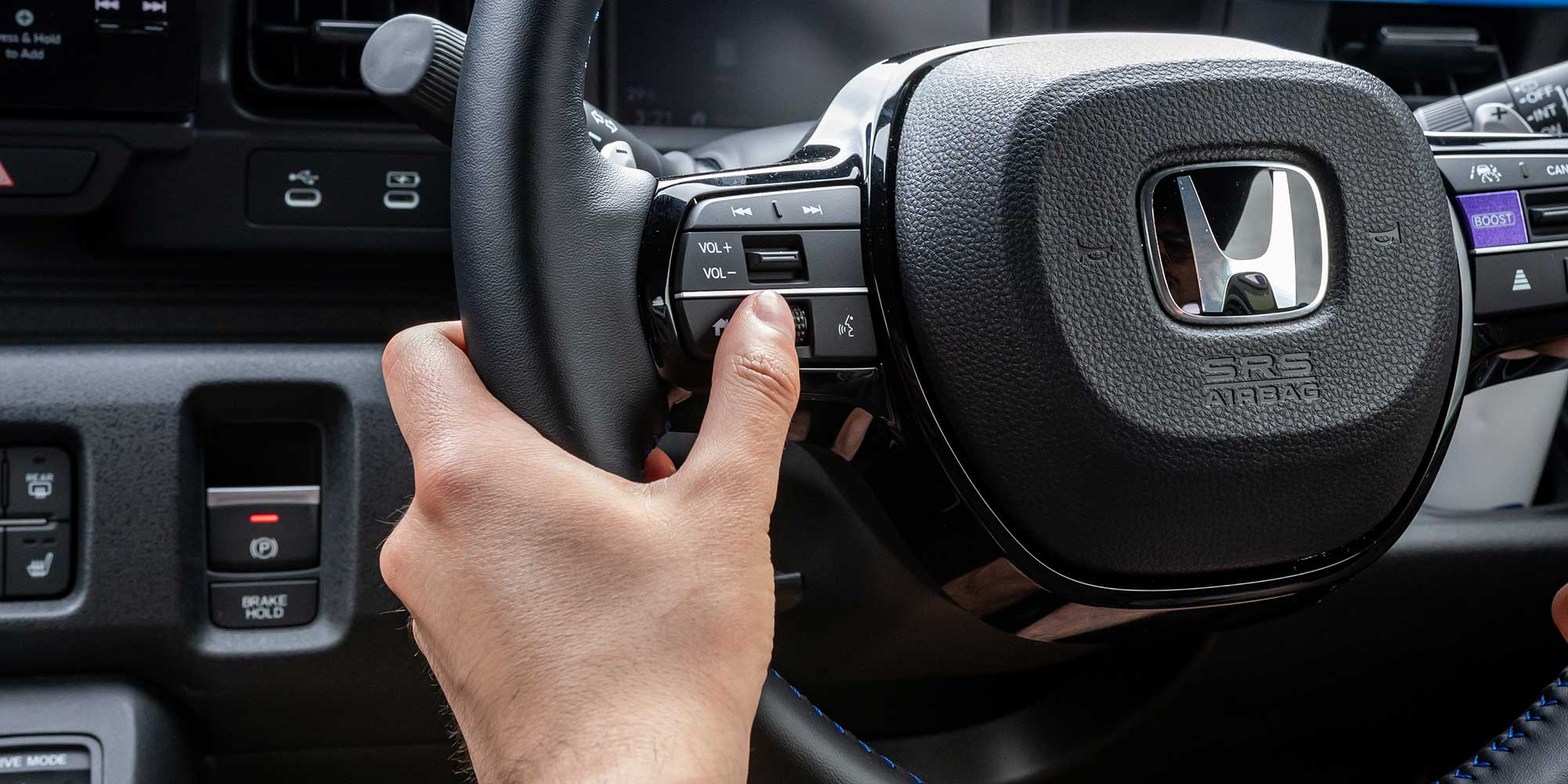 Hand on steering wheel of a Honda Super-N