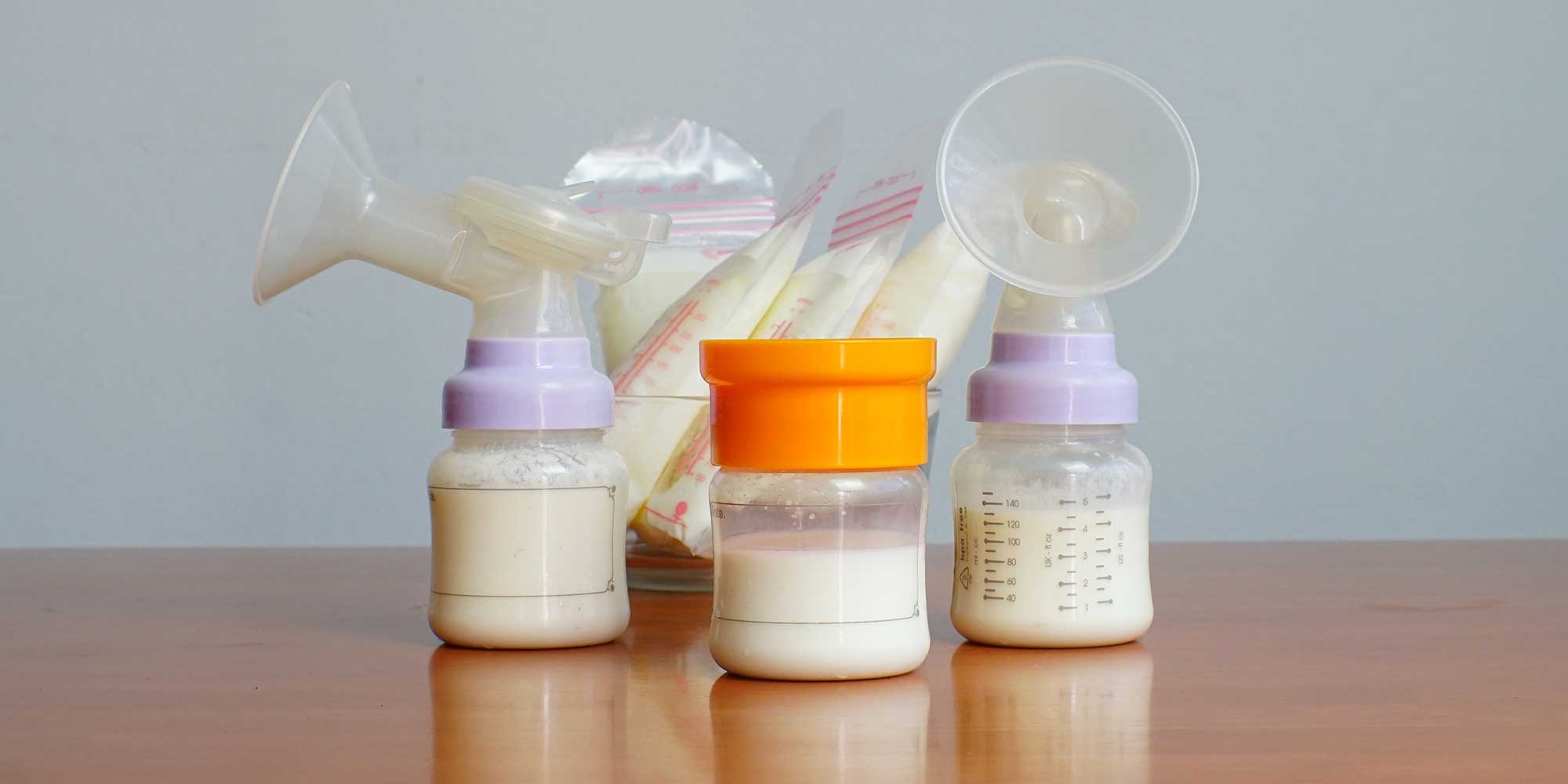 Baby bottles and a breast pump with milk