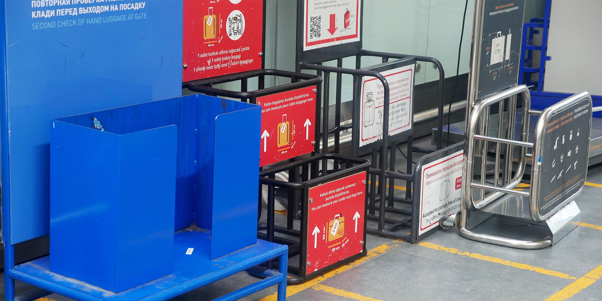 A picture of multiple luggage sizers at the airport from different airlines