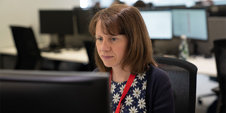 Woman sitting at a desk, working at a computer