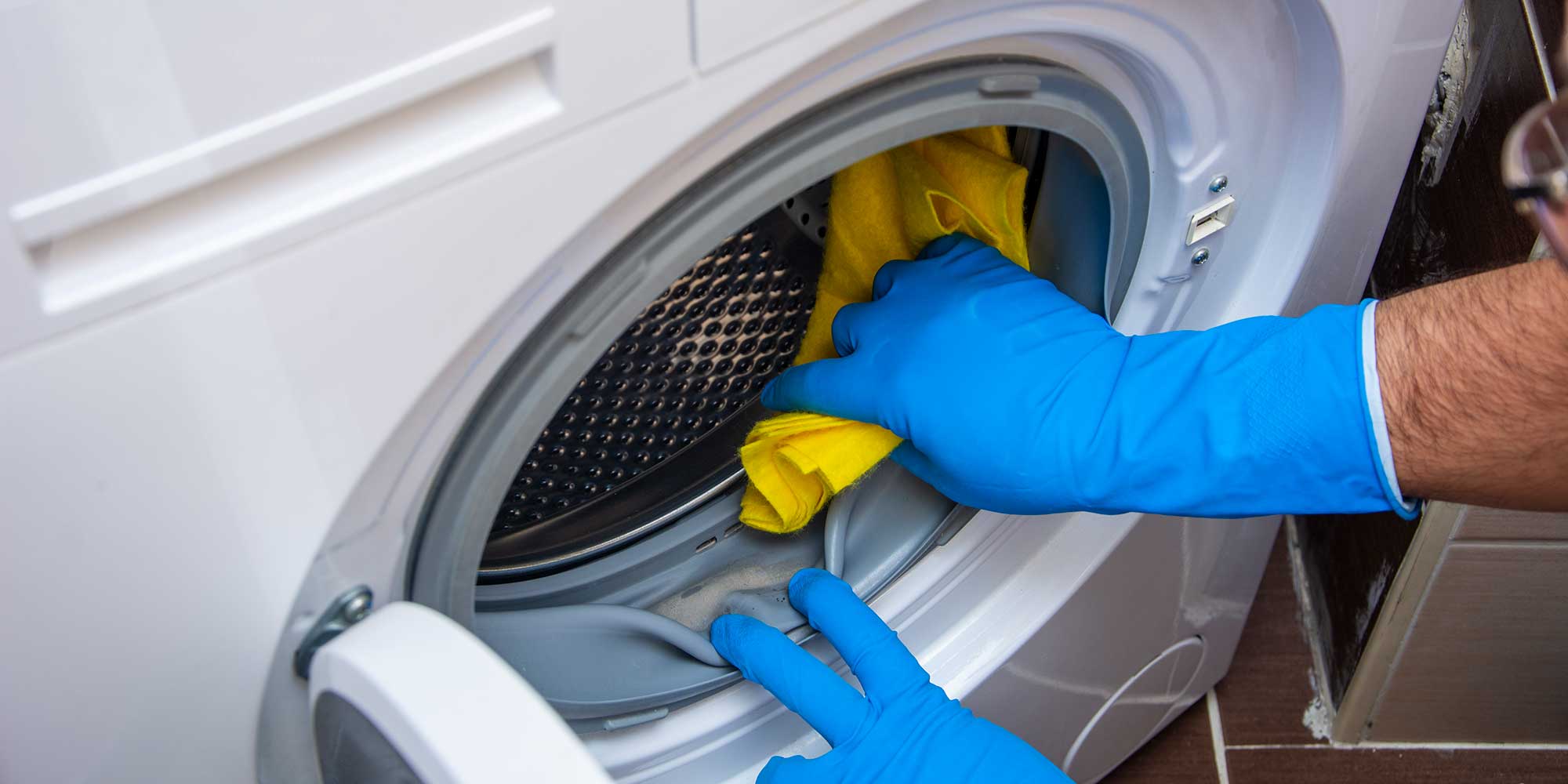 Person cleaning washing machine seal