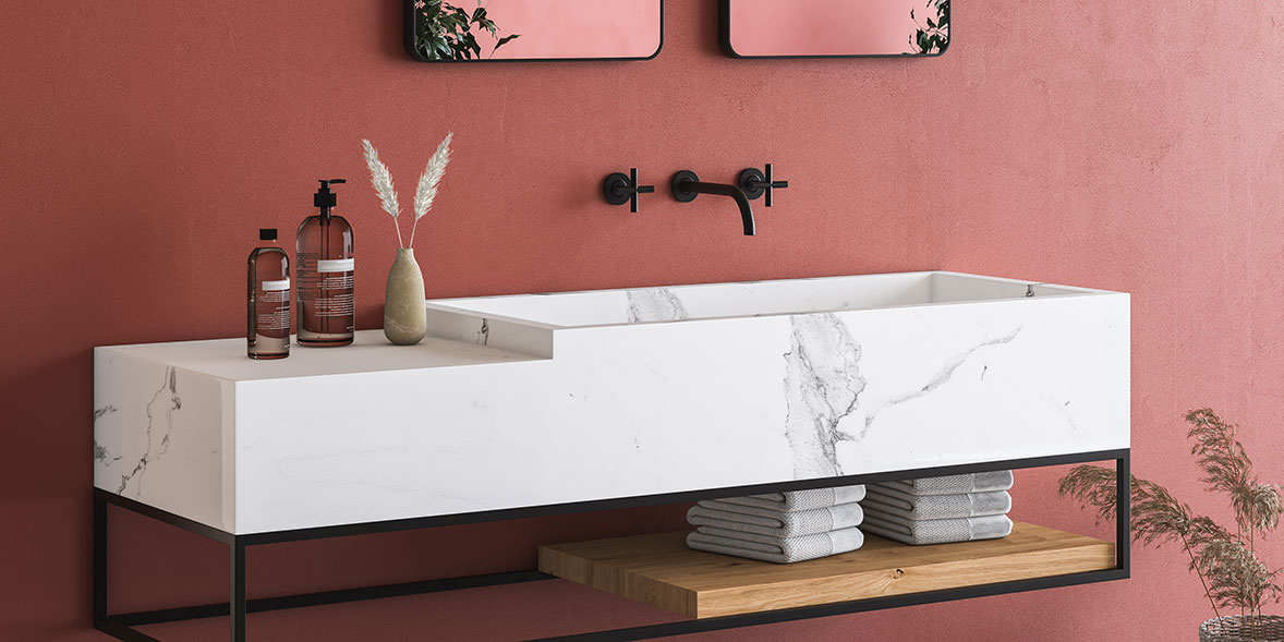 a large floating marble sink against a wall painted a blood orange colour