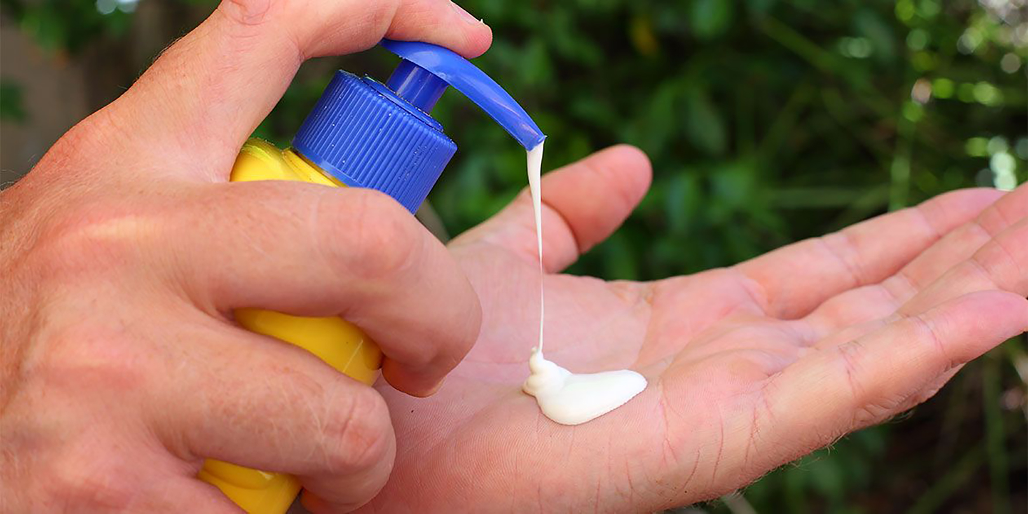 Testing the application of sun cream - picture of someone squeezing sun cream into their hand
