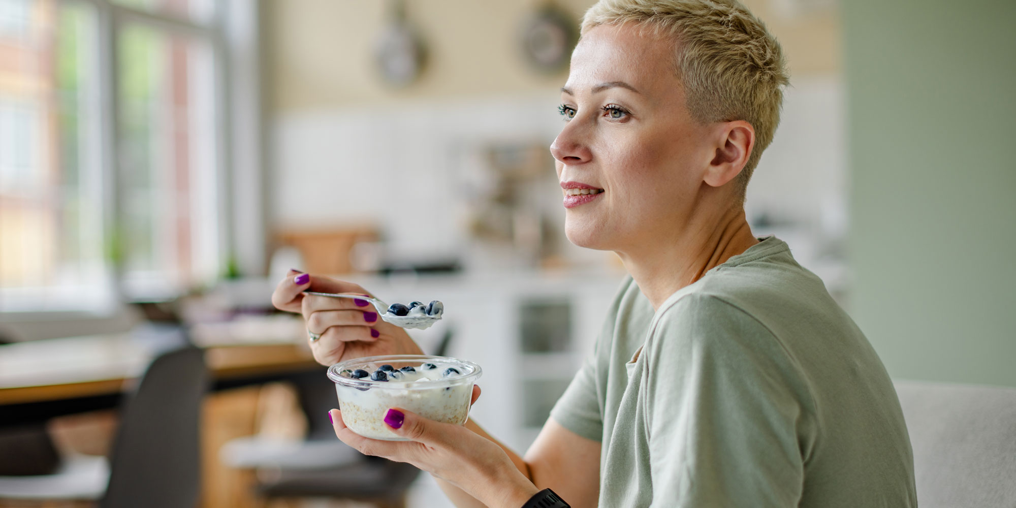 Woman eating yoghurt for probiotics and gut health 