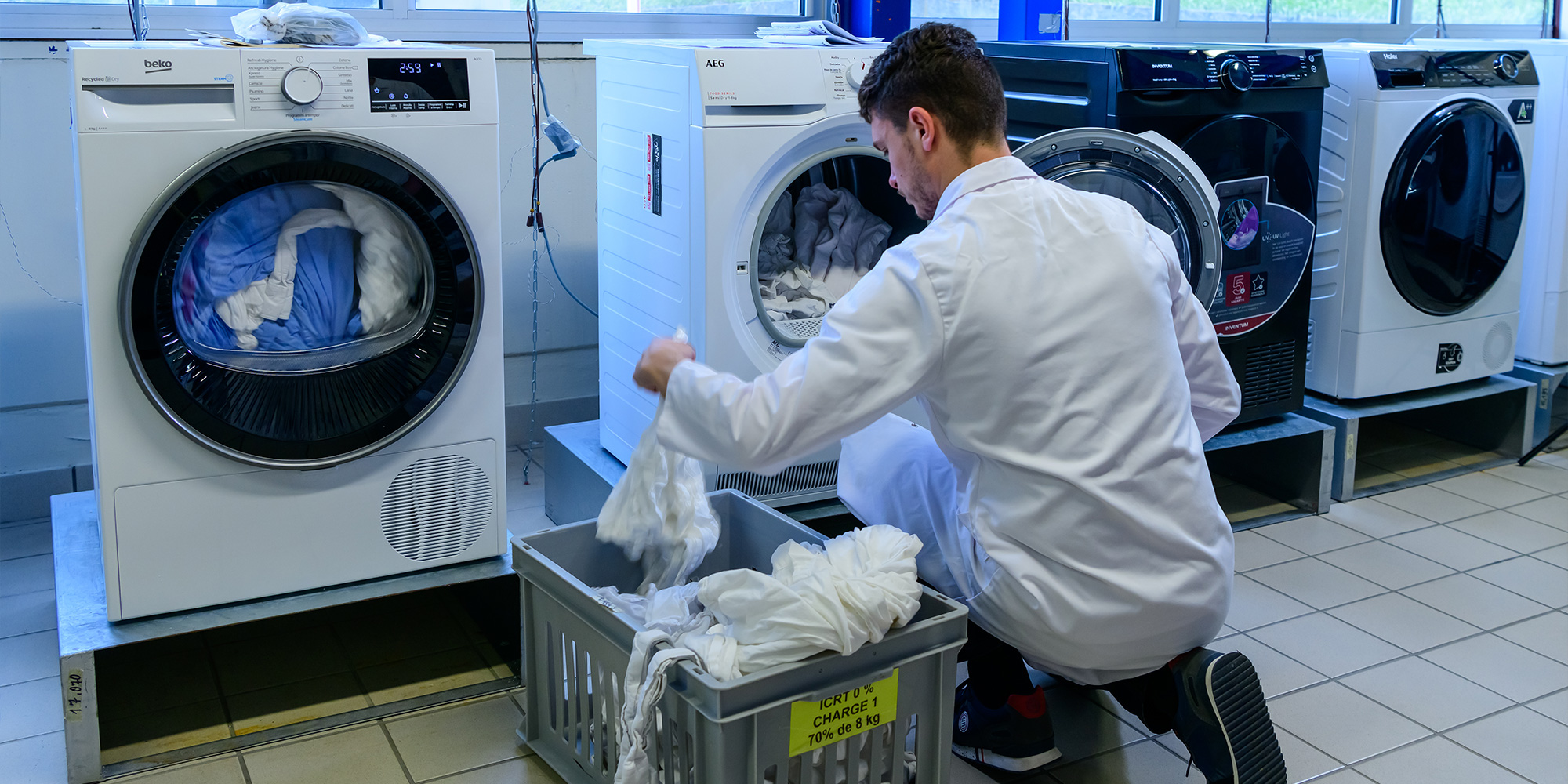 Lab technician loading fabric into a tumble dryer