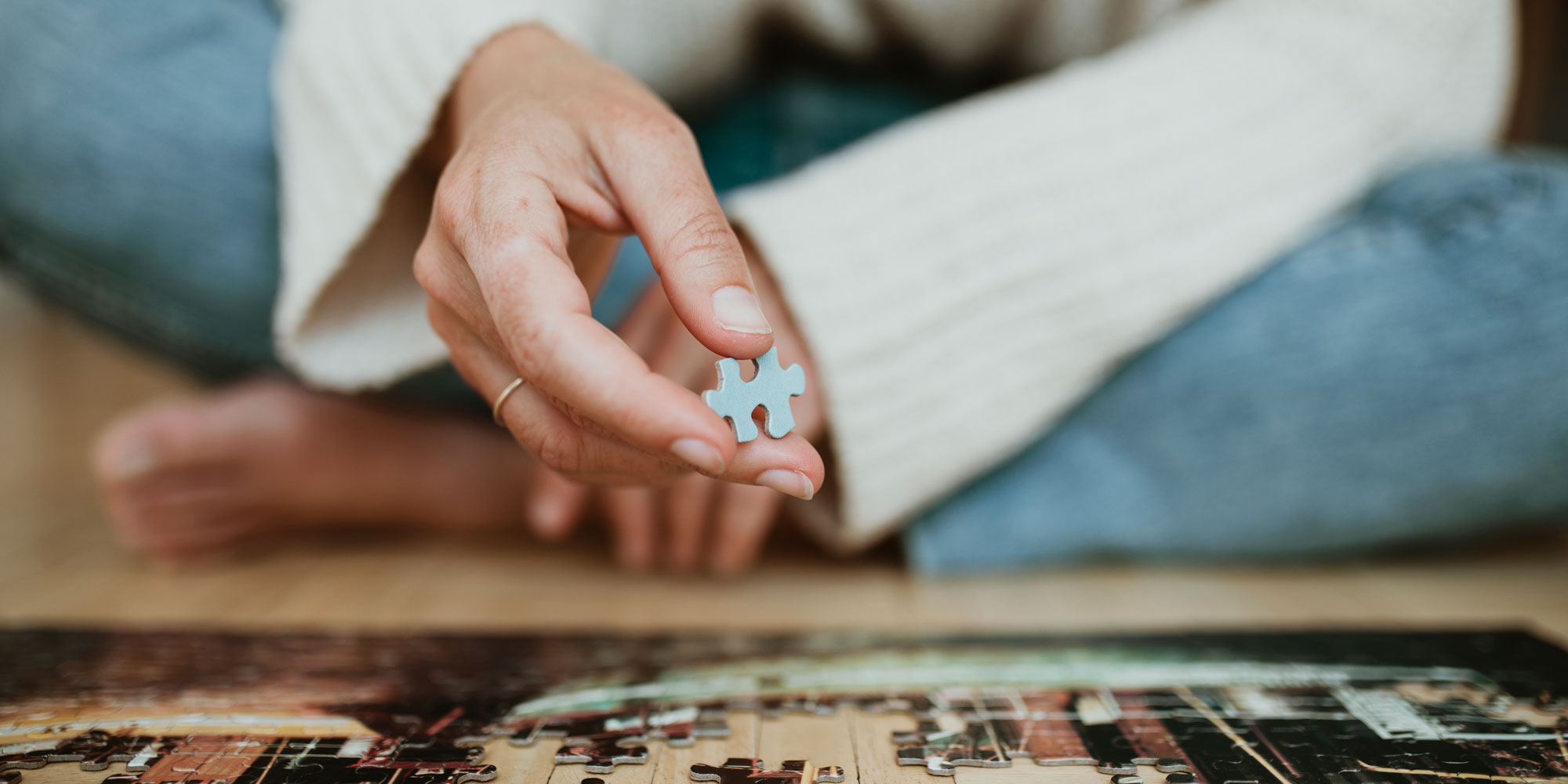 Hands of a person completing a jigsaw
