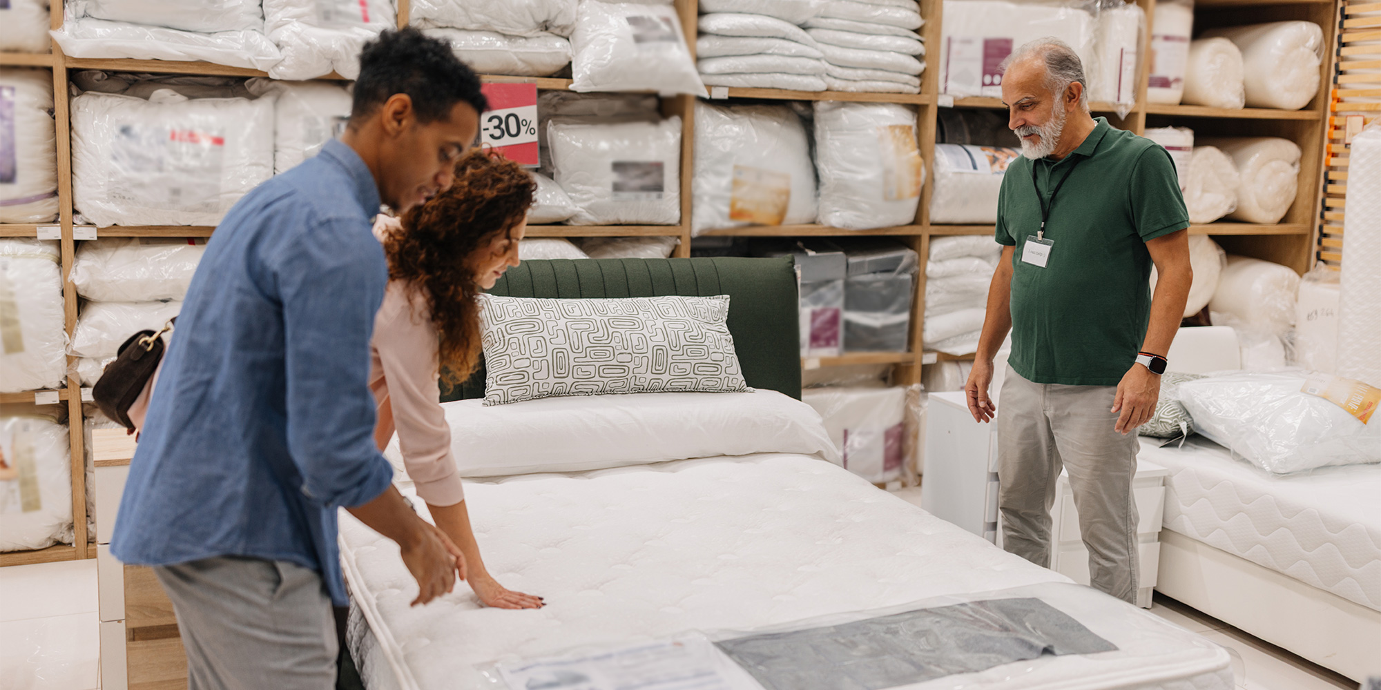 Couple testing a mattress during a mattress sale in store