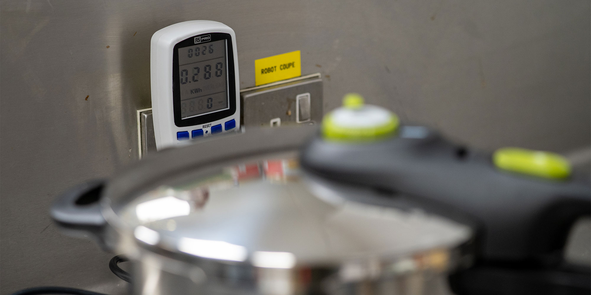 An energy monitor being used to measure how much electricity a pressure cooker is using