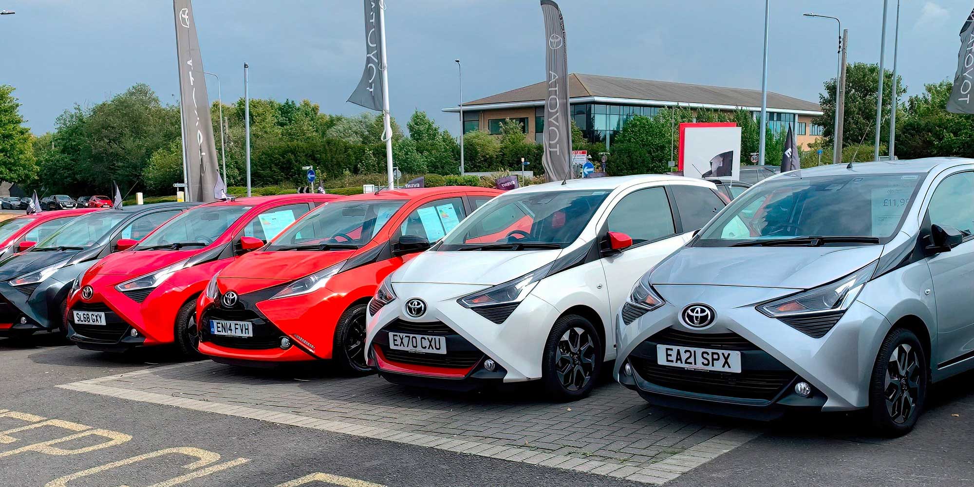 A group of Toyota cars on a dealership forecourt