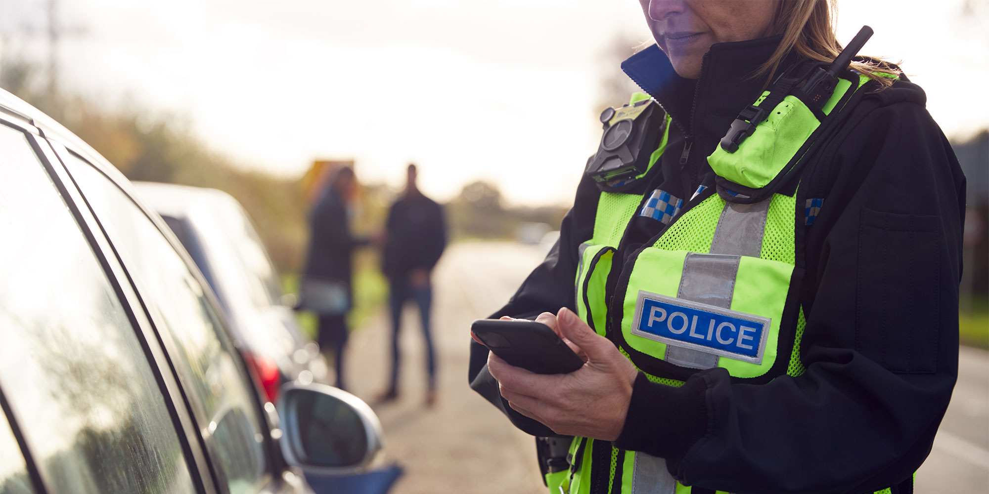 Policewoman standing beside a car